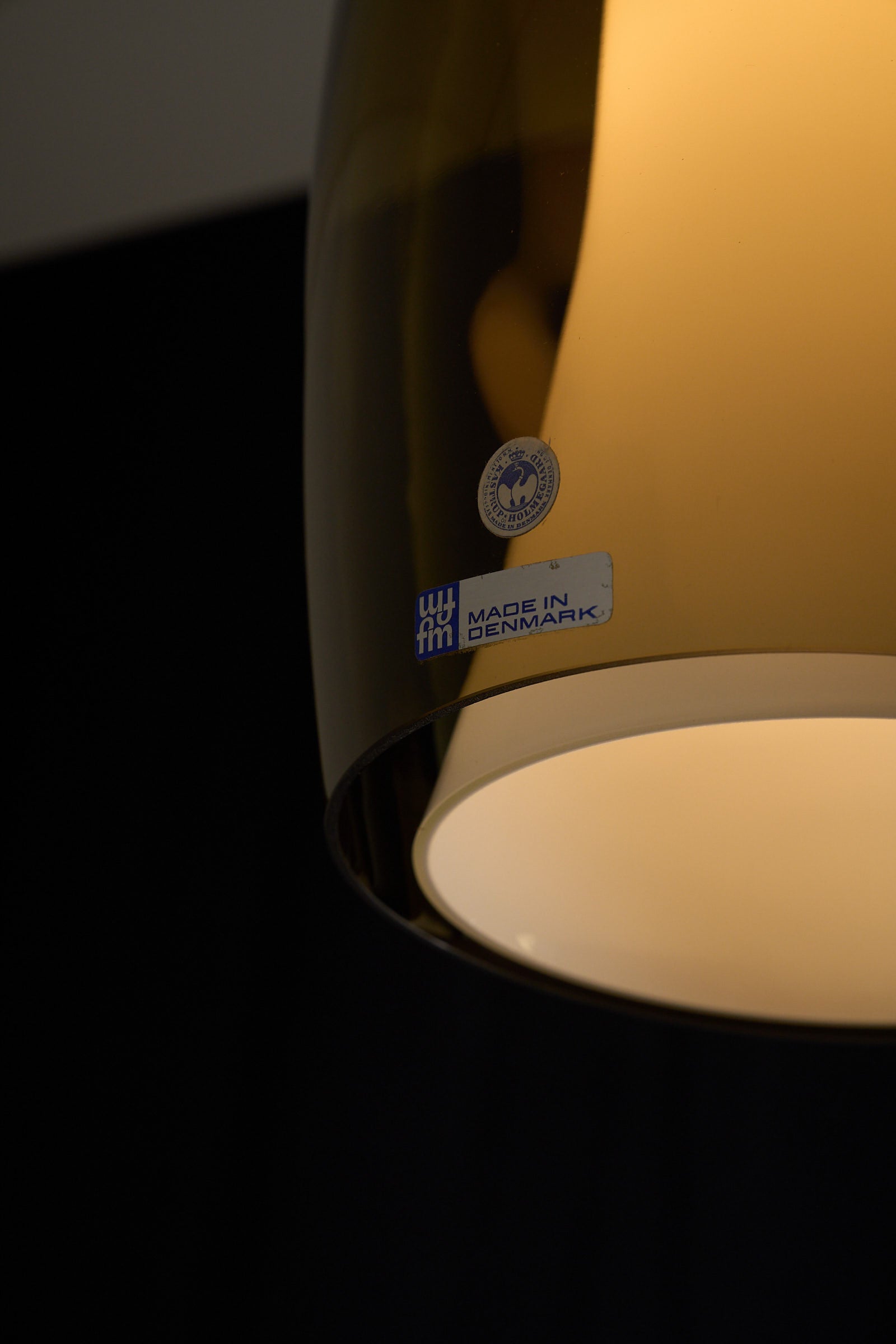 Jo Hammerborg 'Radius' Pendant Lamp for Fog&Mørup close-up showing the smoky amber glass and 'Made in Denmark' label.