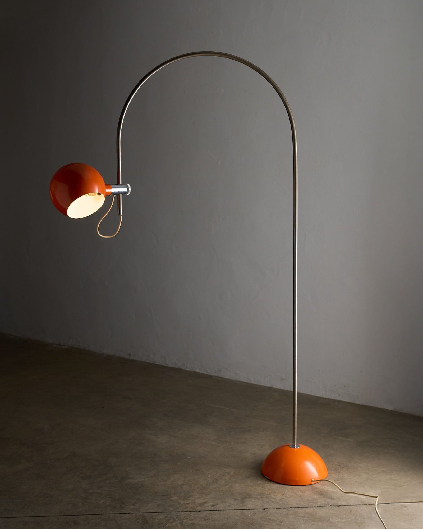 Orange Arc Floor Lamp by Cosack, a 1970s Space Age design with a vibrant orange shade and half-sphere base.