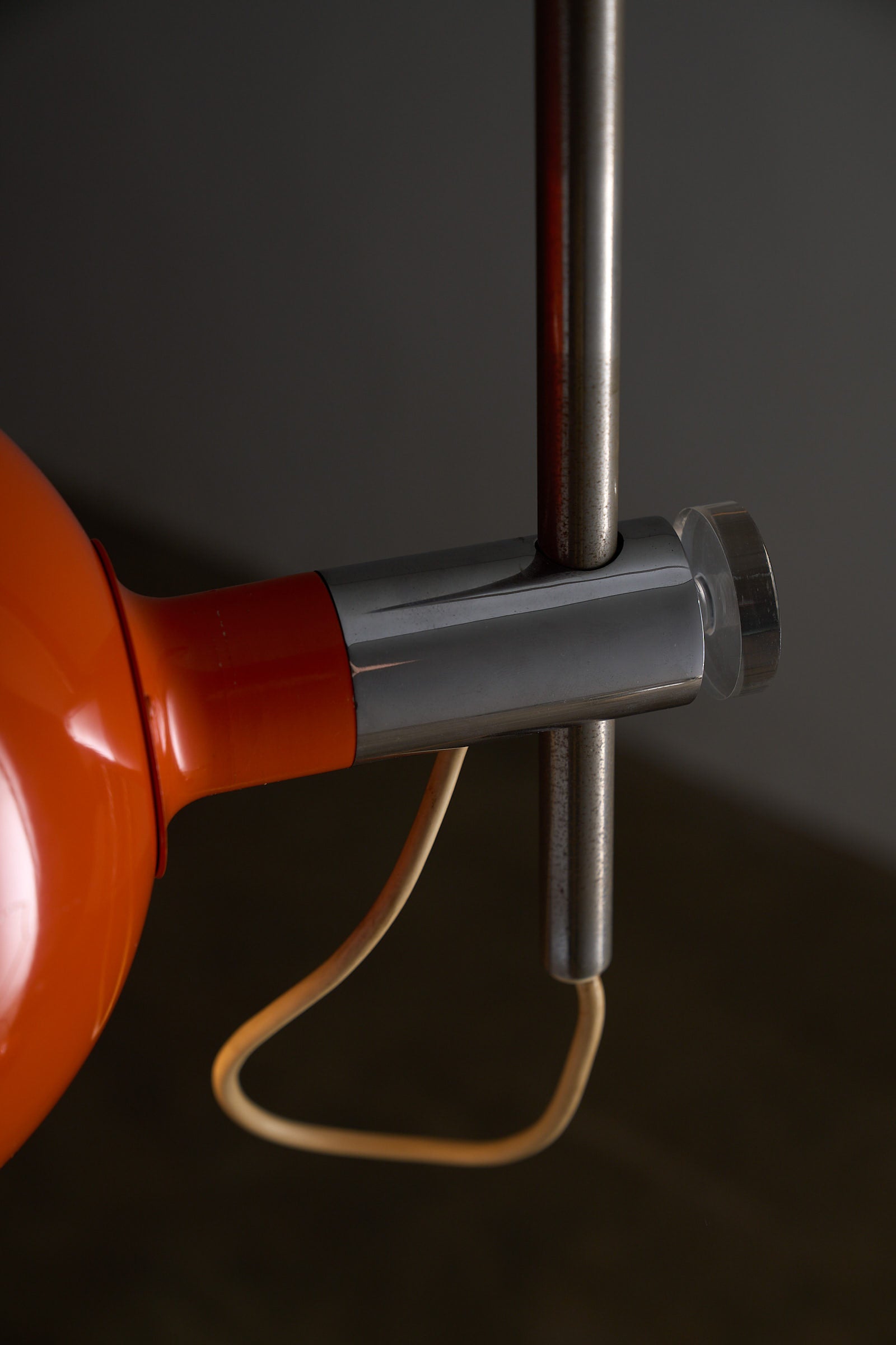 Close-up of the Orange Arc Floor Lamp by Cosack showcasing its vibrant orange shade and sleek metal design.
