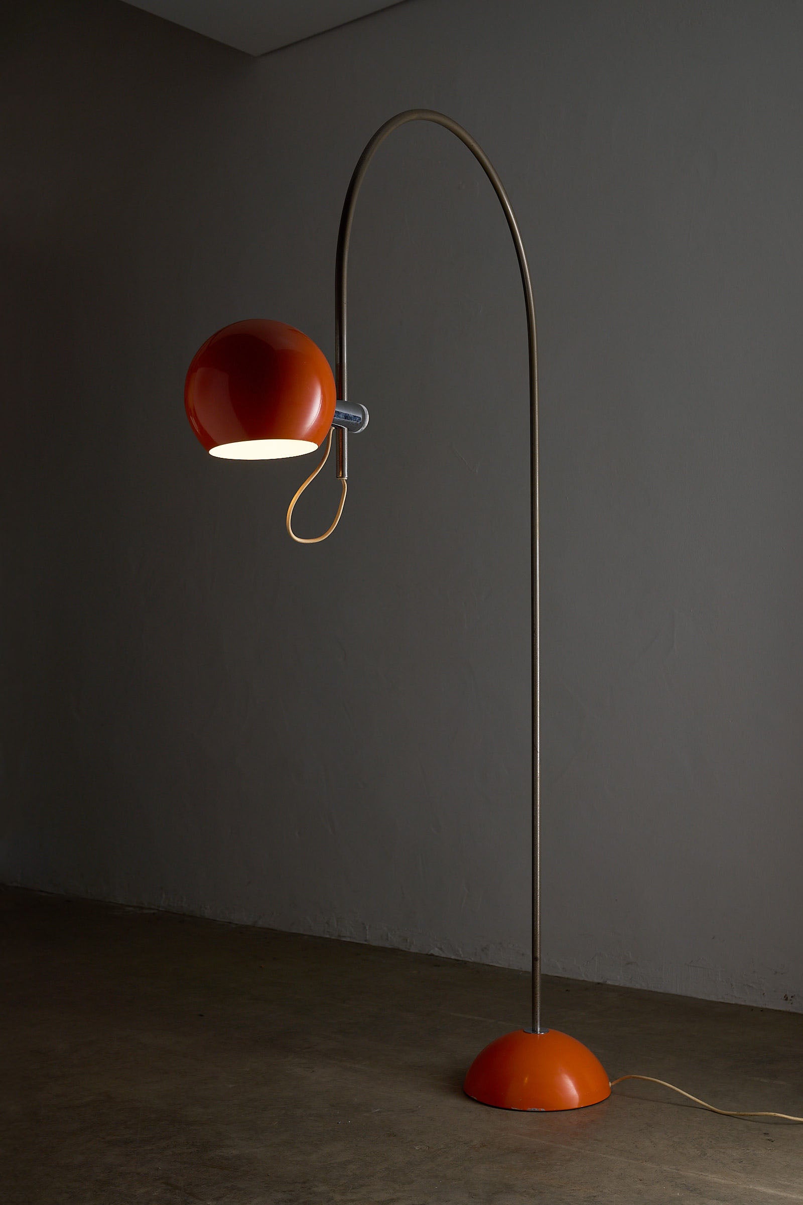 Orange Arc Floor Lamp by Cosack showcasing a bold, vibrant design with a half-sphere base and adjustable shade.