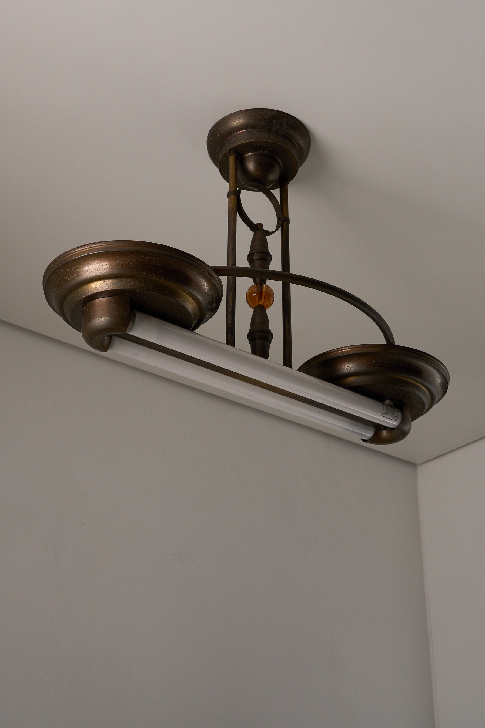 Antique Art Deco Double Fluorescent Ceiling Fixture in Patinated Bronze, featuring amber glass bead and decorative end caps.