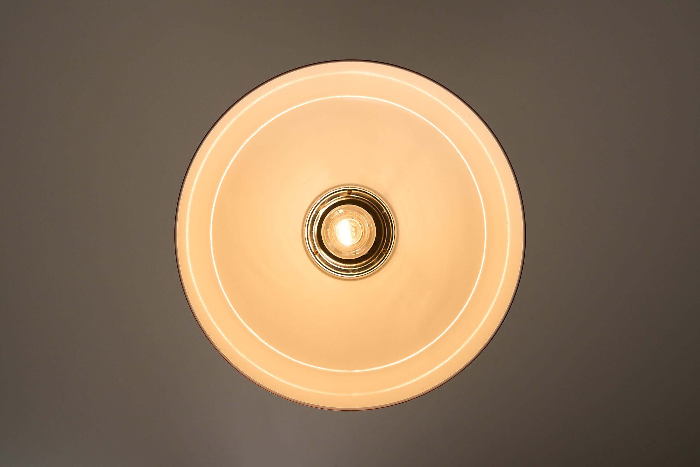 Translucent Orange Pendant with Dual Light Sources viewed from below, showcasing its elegant round design and warm glow.