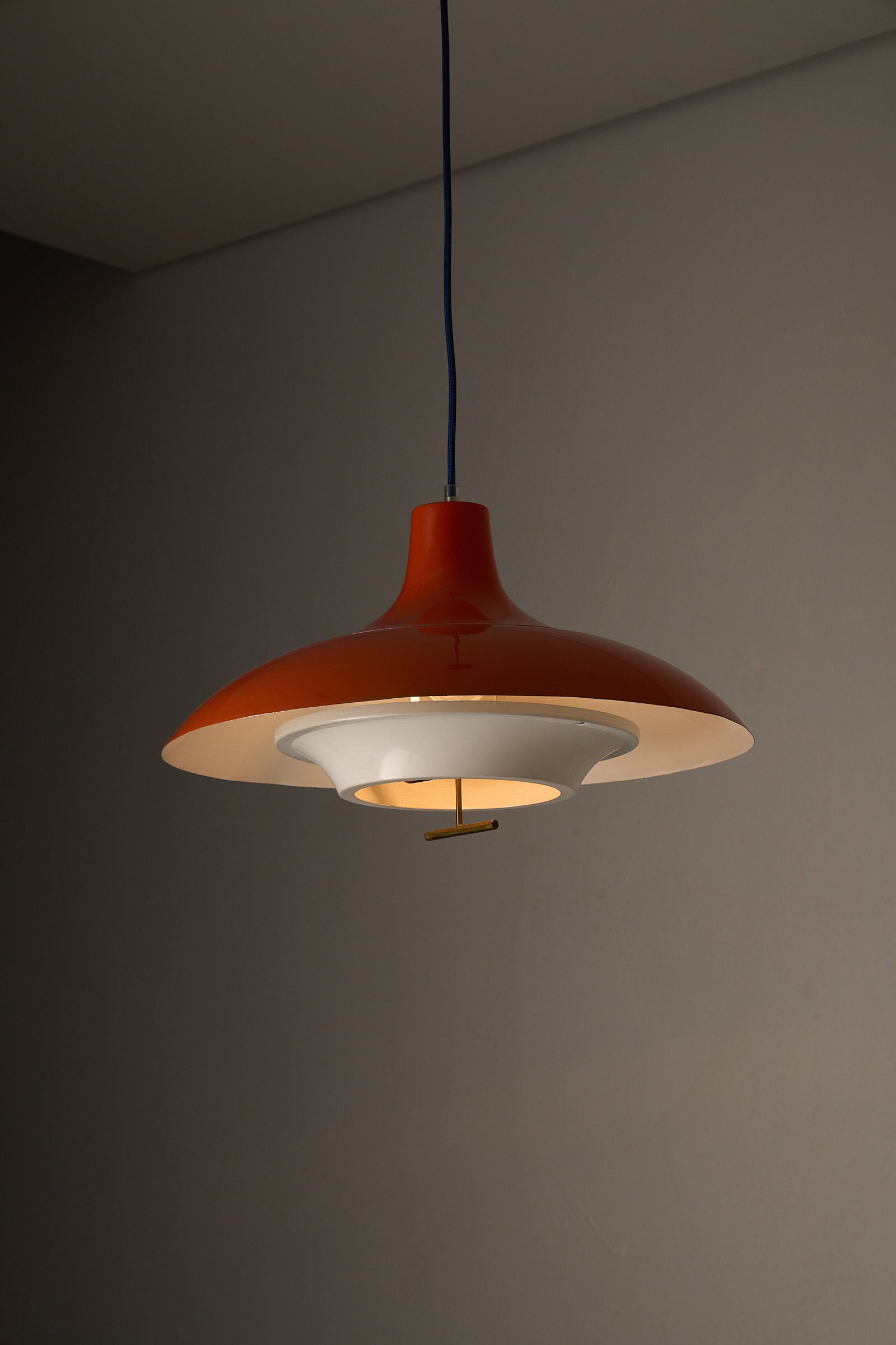 1960s Orange Pendant with Brass Detail hanging lamp featuring a glossy orange exterior and white interior.
