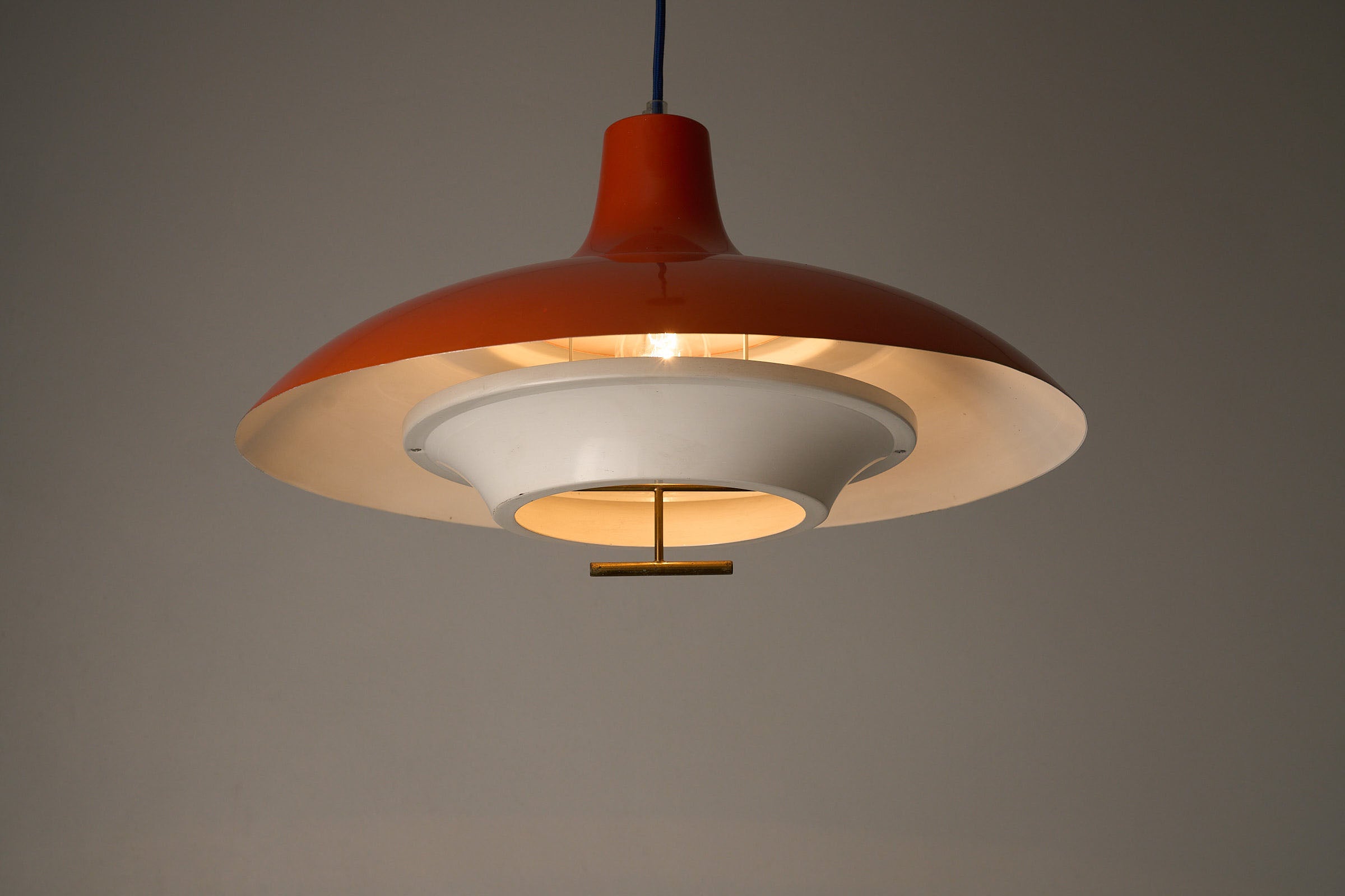 1960s Orange Pendant with Brass Detail featuring a high-gloss orange shade and matte white inner shade.