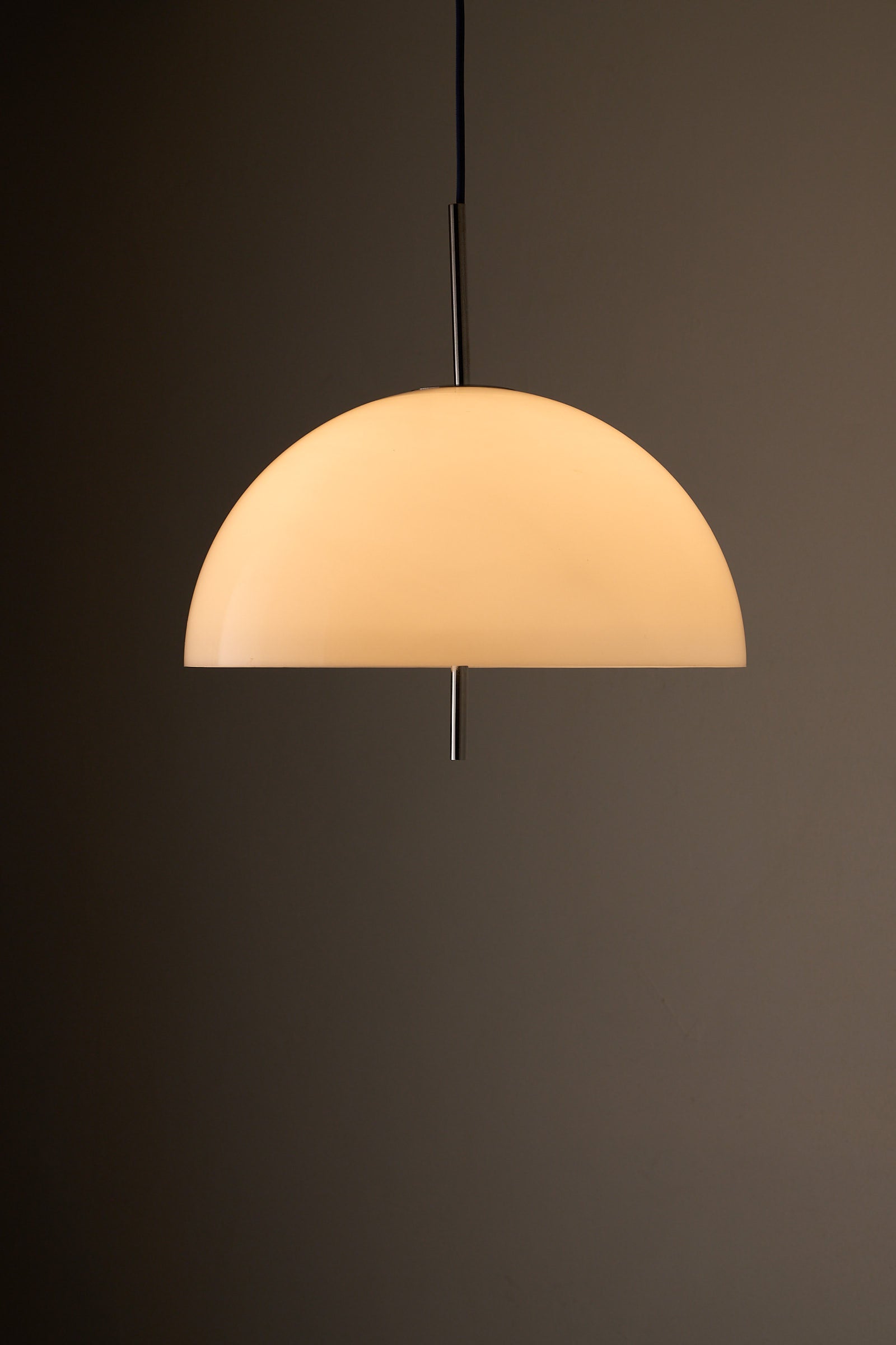 Wila Minimalist Semi-Sphere Pendant Lamp with Chrome Detail hanging against a dark background.