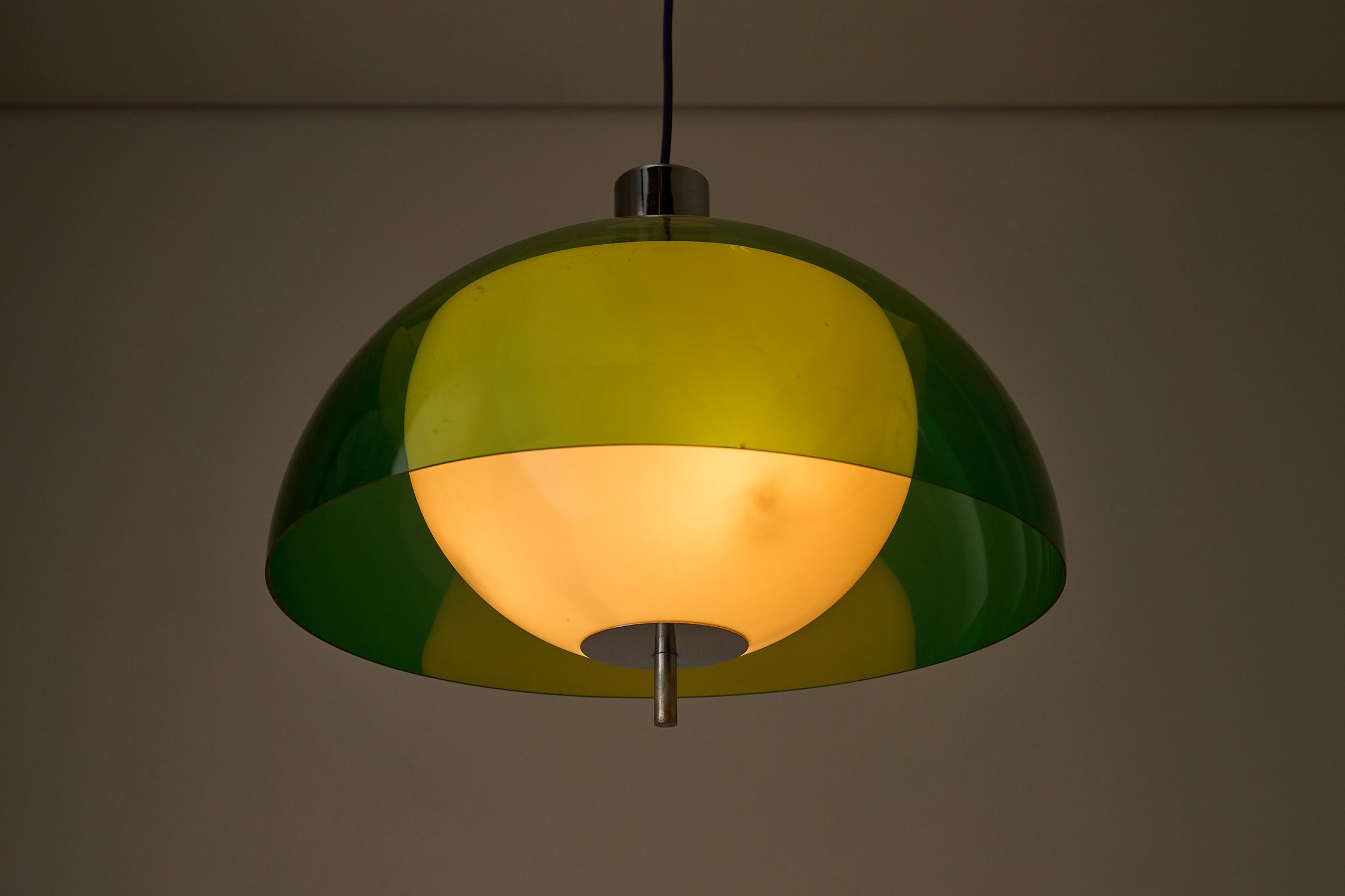 Space Age Layered Plexiglass Pendant in Green and White illuminating a room with warm ambient light.
