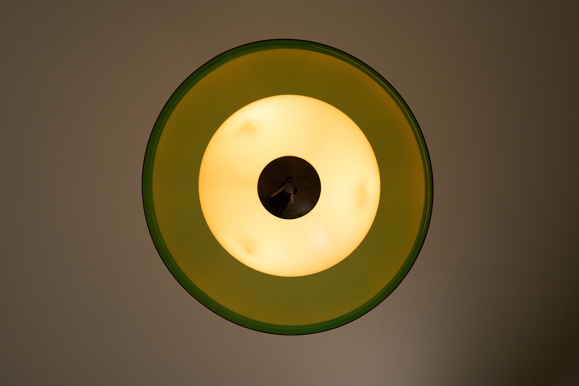 Space Age Layered Plexiglass Pendant in Green and White with a translucent green outer shade and warm ambient light.