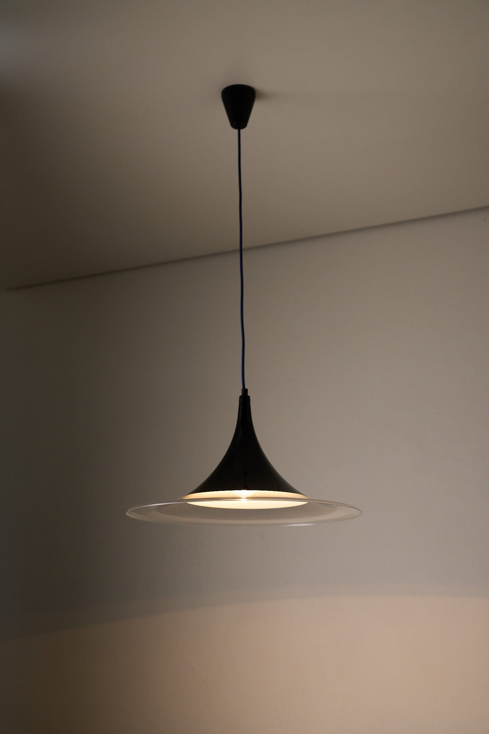 Black and Clear Acrylic Pendant lamp with conical silhouette providing focused illumination.