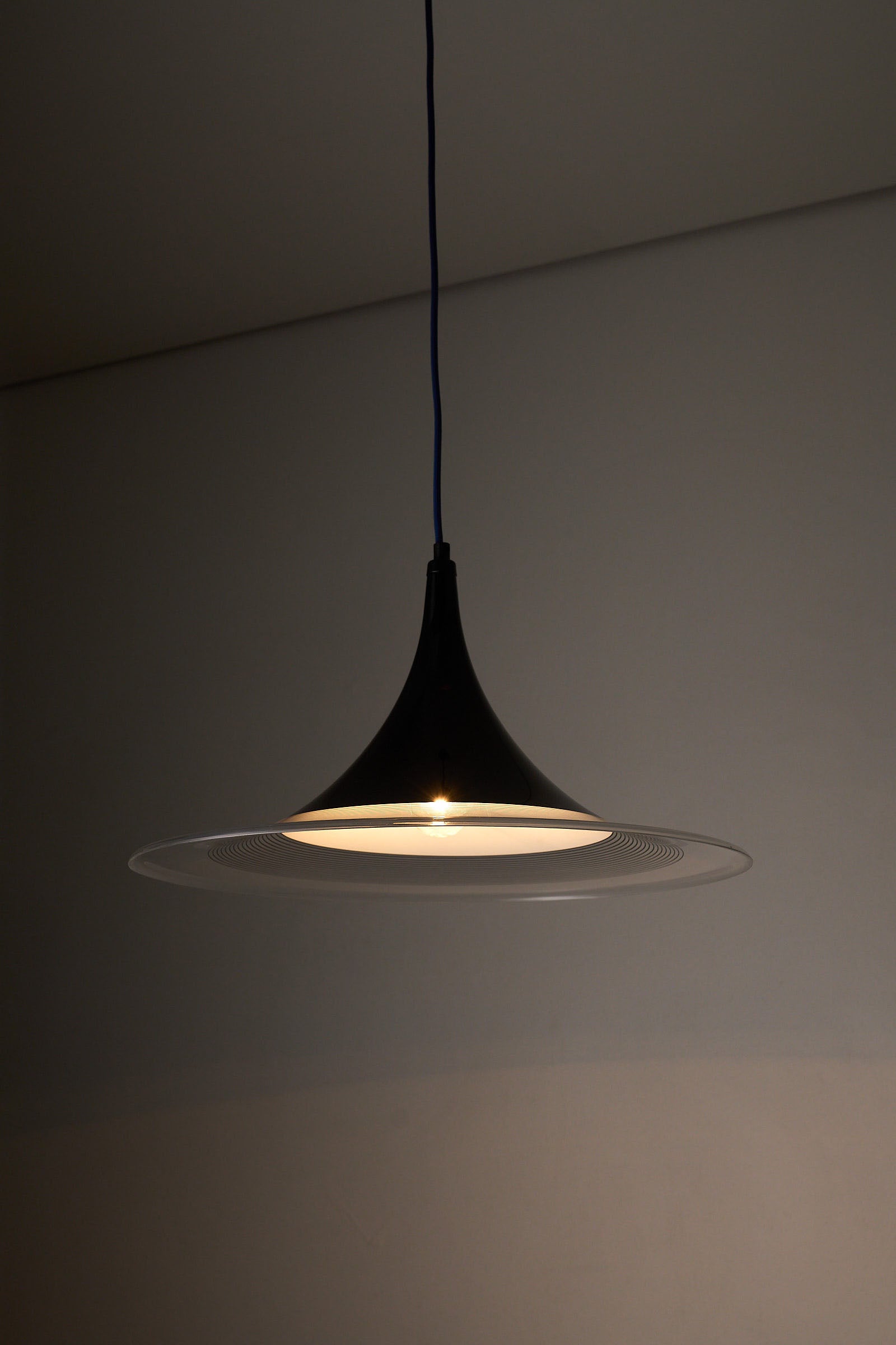 Black and Clear Acrylic Pendant lamp with conical silhouette and strong downward light.