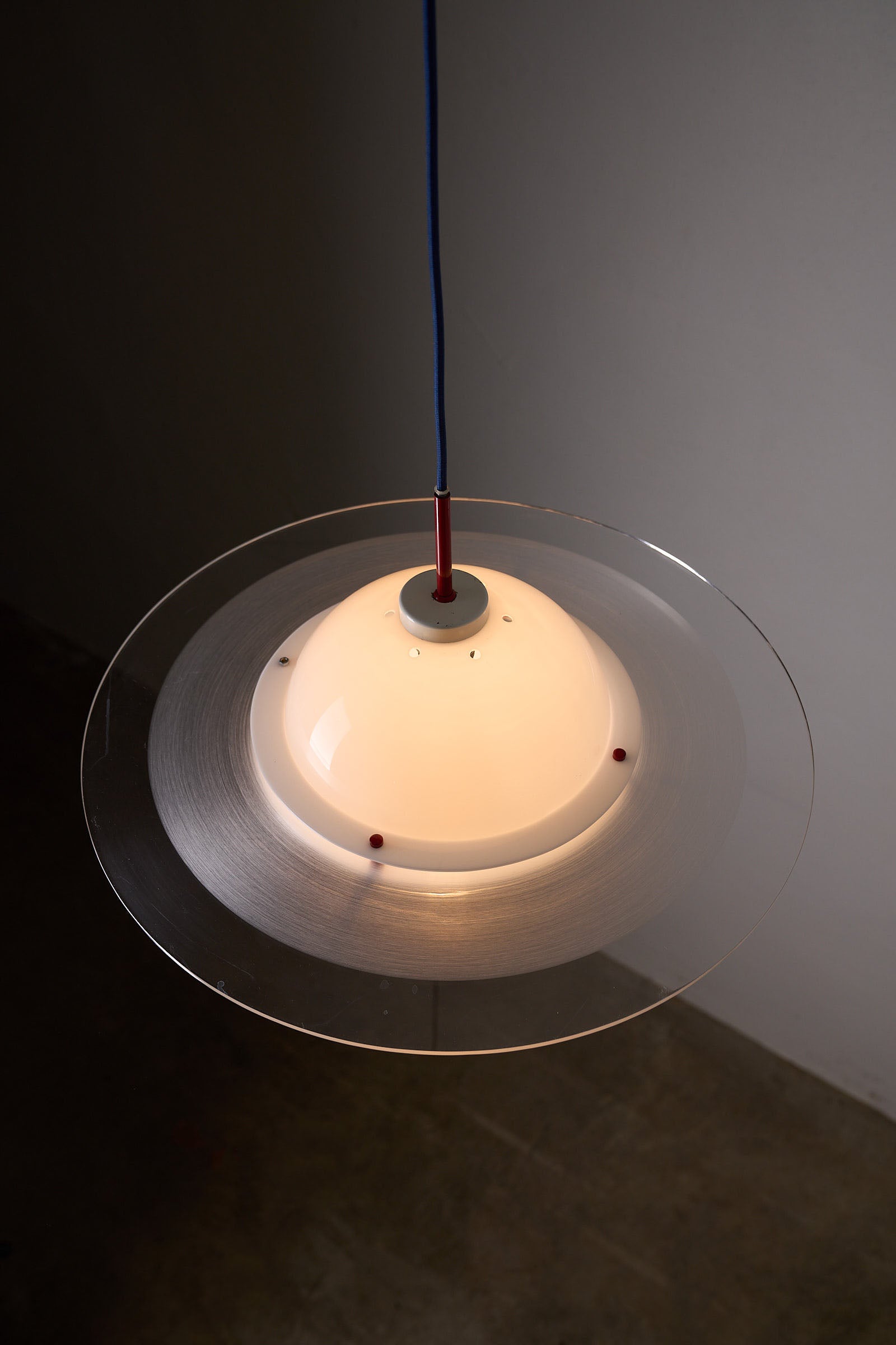 Space Age 'Saturn' Plexiglass Pendant Lamp with Red Details hanging overhead, showcasing its iconic design and vibrant colors.