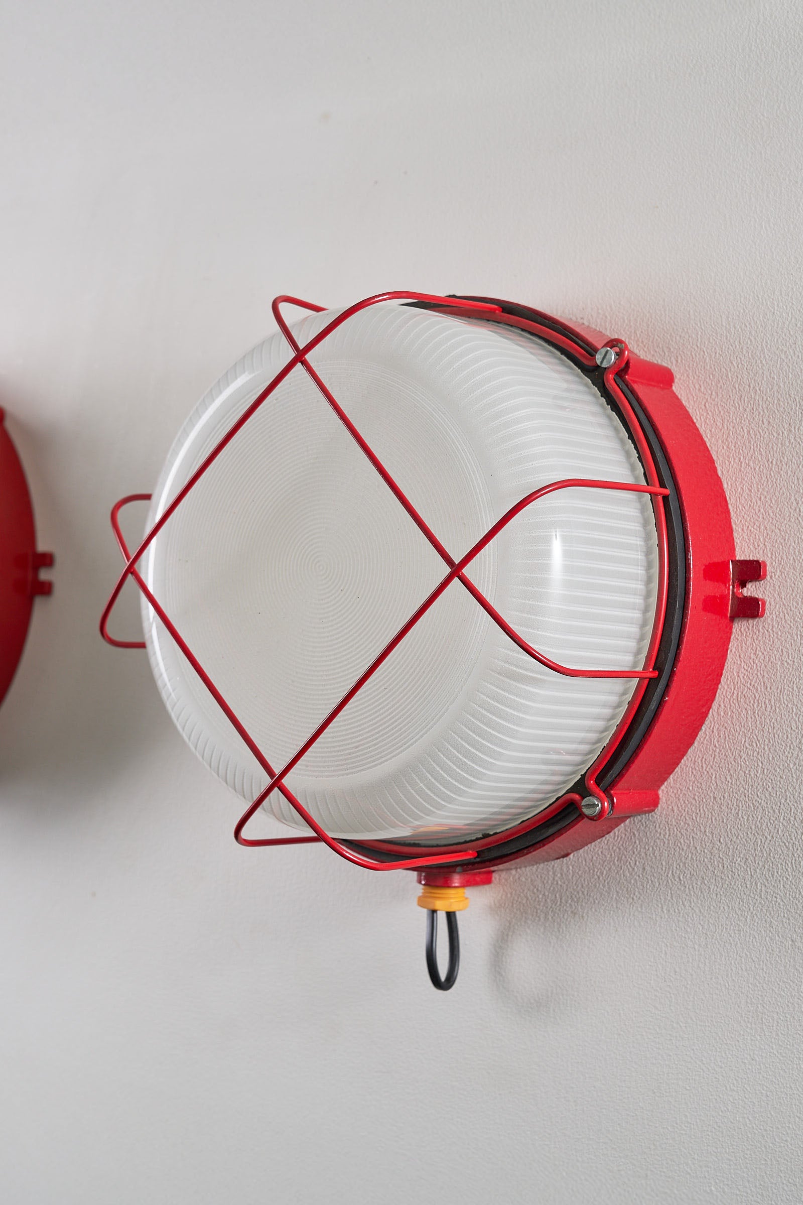 Pair of Red Marine Cage Lamps (set) - industrial flush mount exterior sconces with vibrant red enamel finish.