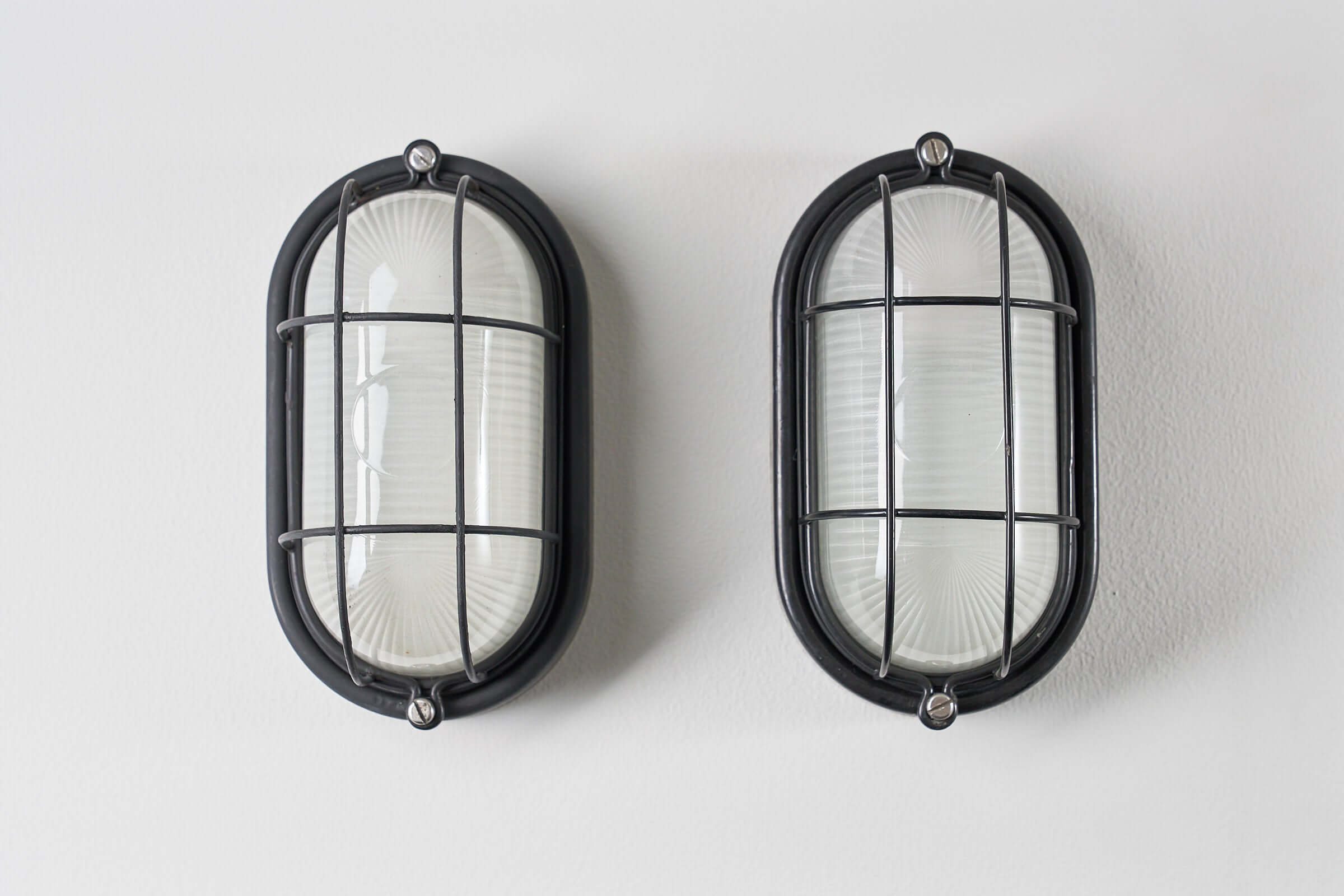 Set of 2 Black Flush-Mount Oval Cage Lamp featuring industrial style black enamel finish and glass diffusers.