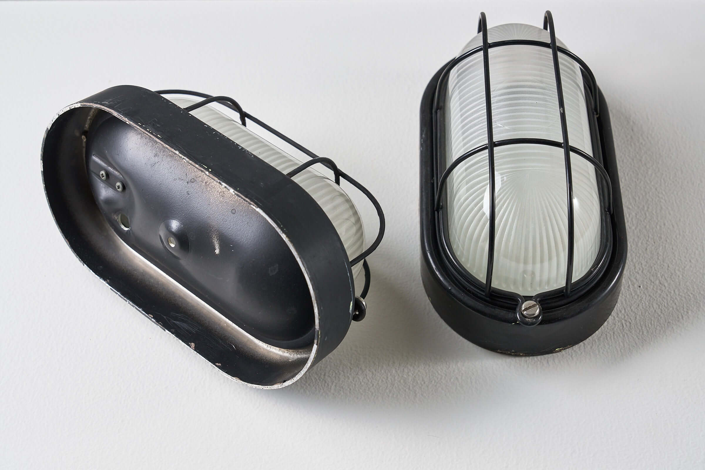 Set of 2 Black Flush-Mount Oval Cage Lamp showcasing an industrial design with glass diffusers and black enameled body.
