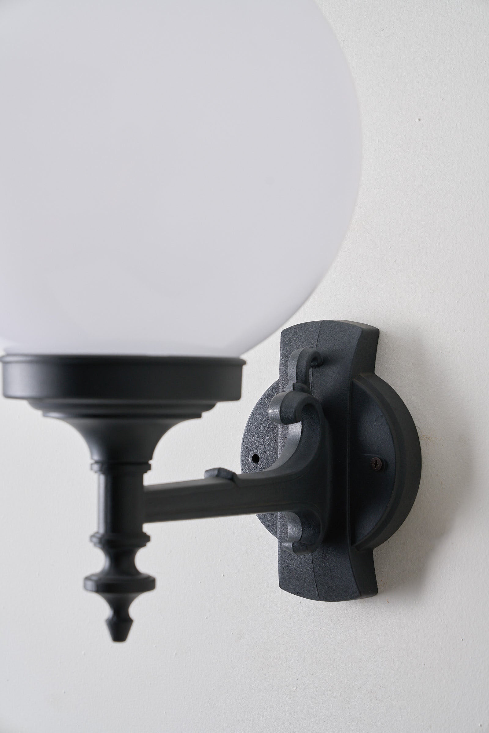 Traditional Outdoor Spherical Wall Lamp by Lothus mounted on black bracket, providing elegant outdoor lighting.