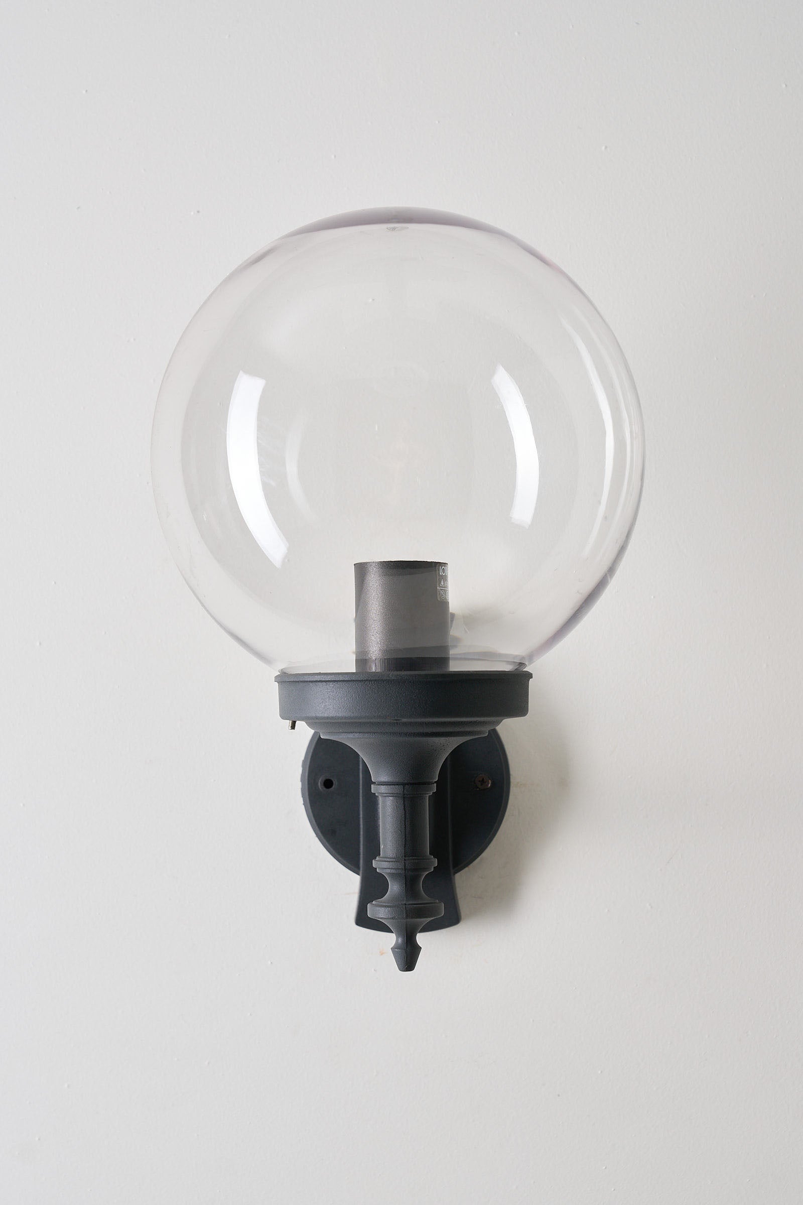 Traditional Outdoor Transparent Spherical Wall Lamp mounted on a black bracket showcasing a clear globe for exterior lighting.