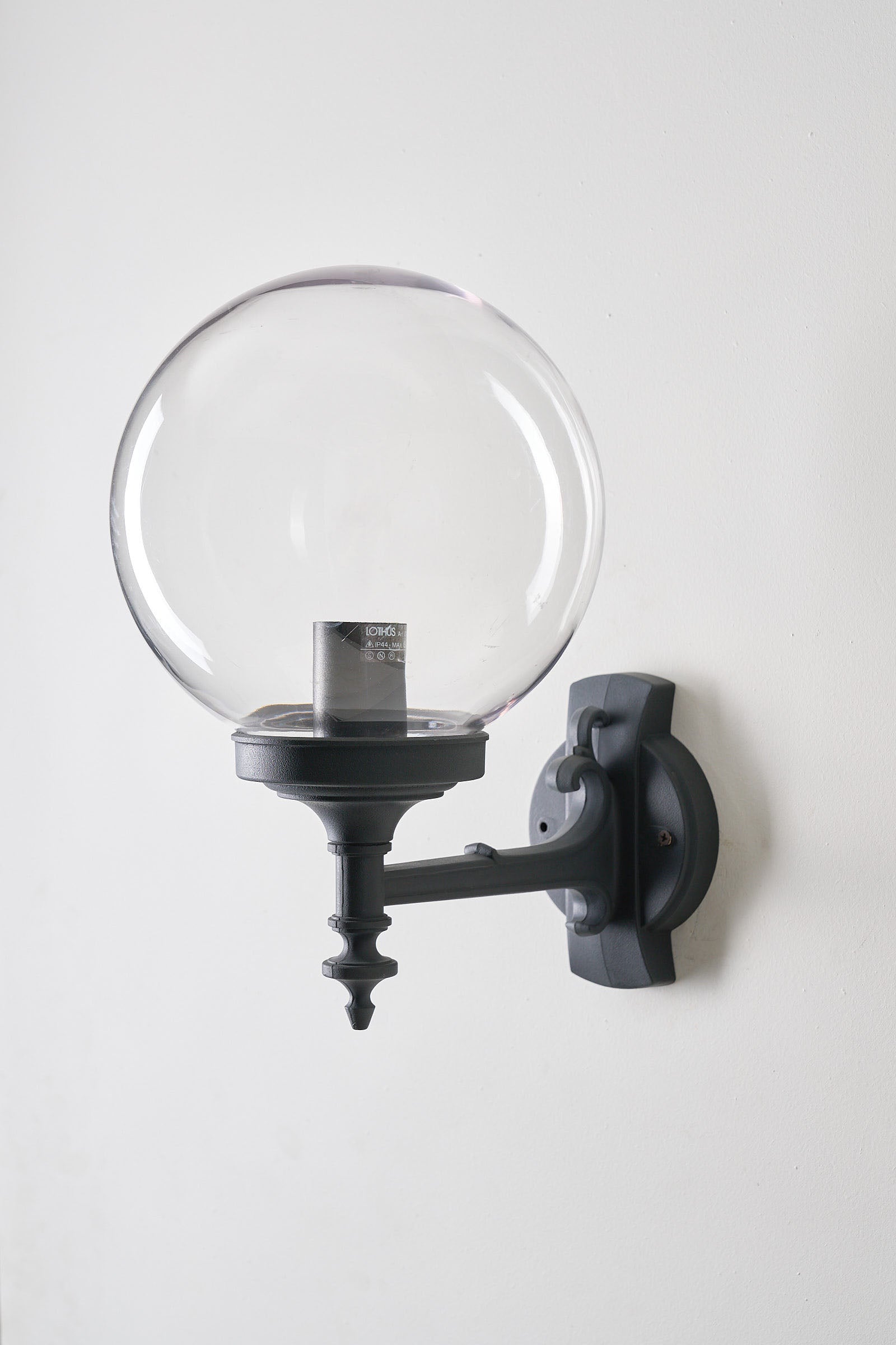 Traditional Outdoor Transparent Spherical Wall Lamp mounted on a black-lacquered bracket for exterior lighting.