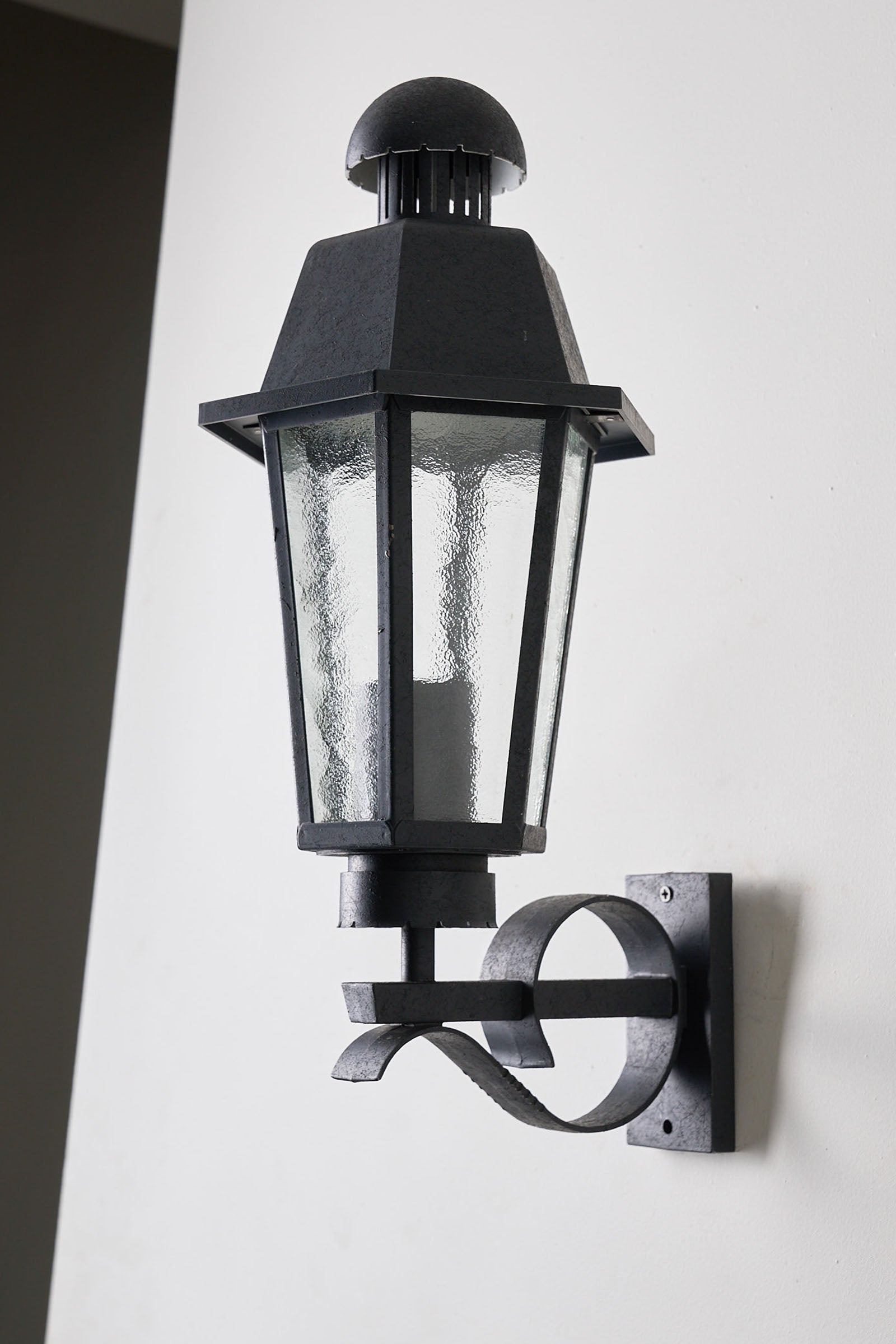 Outdoor Wall Lantern Bega Boom Traditional Style mounted on wall, featuring cast metal frame and bubbled glass panels.