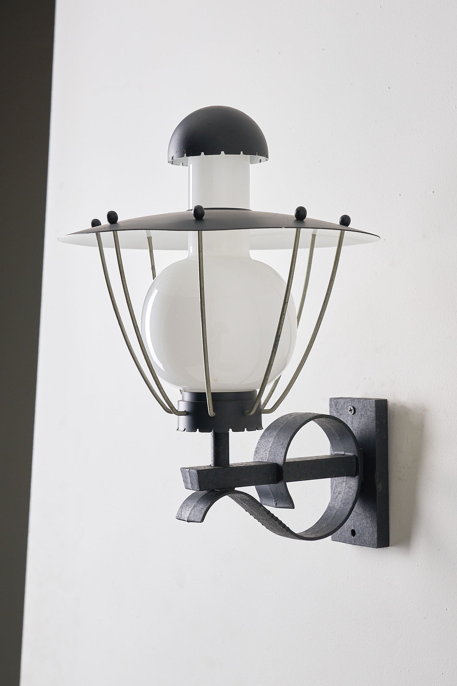 Bega Boom Outdoor Wall Light featuring a vintage exterior sconce with black metal and opaline glass for exterior lighting.