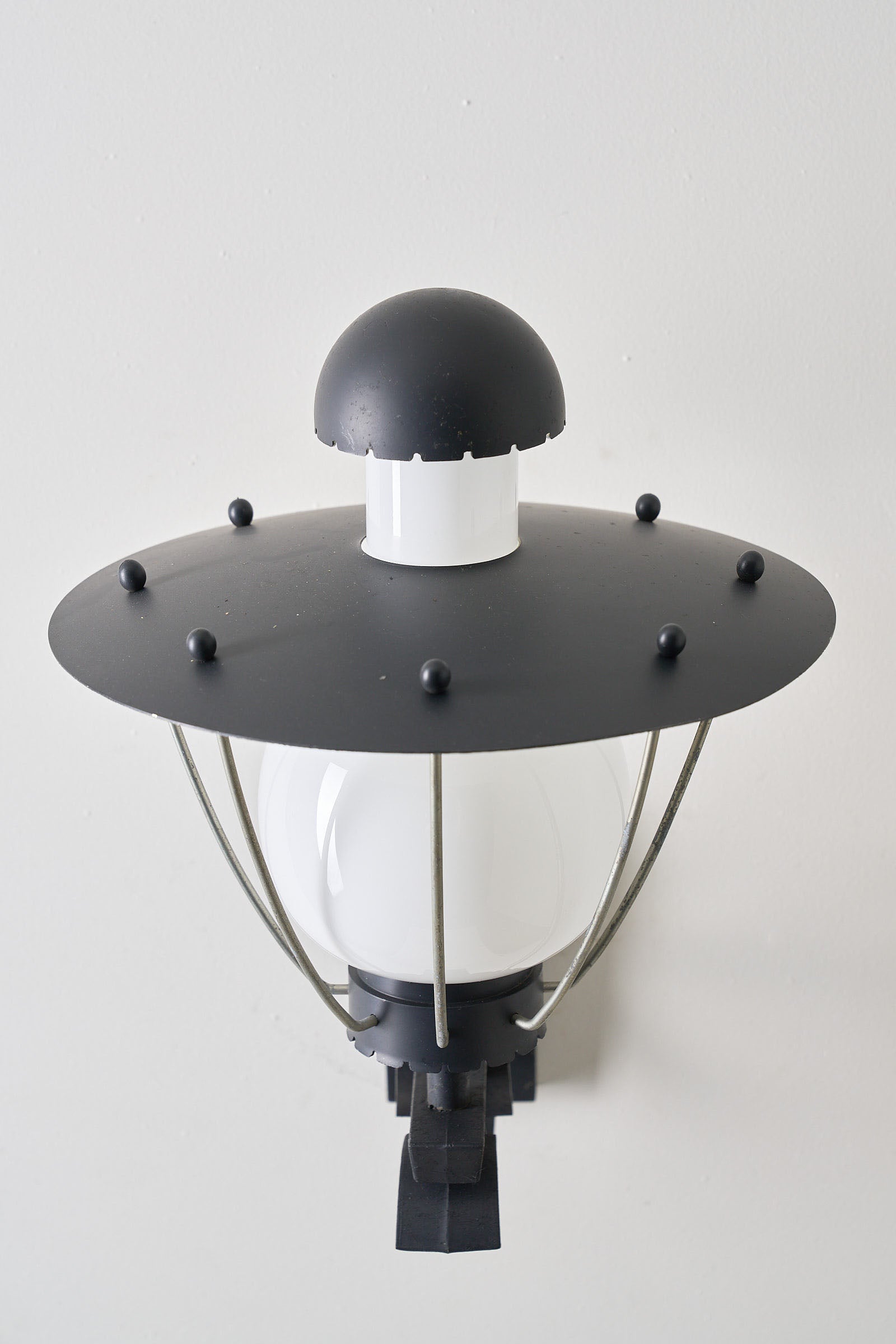 Bega Boom Outdoor Wall Light showcasing black metal construction and opaline glass diffuser for exterior lighting.