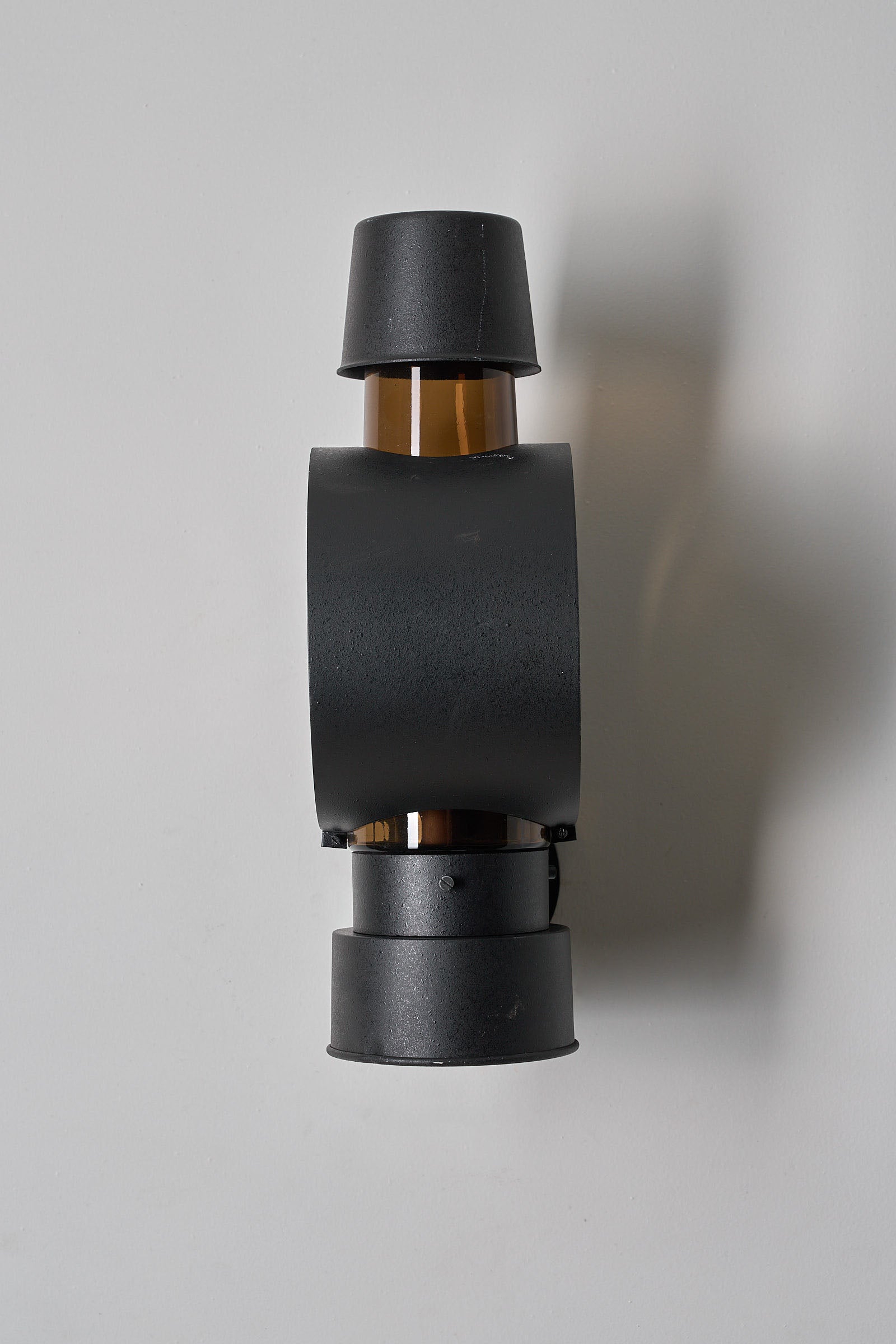 Bega Boom Outdoor Sconce Cylindrical Amber Glass top view showcasing amber-brown glass and dark metal design for exterior lighting.