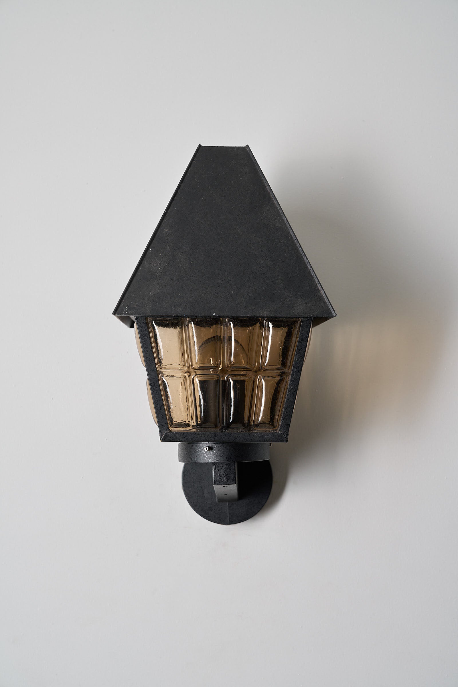 Bega Boom Outdoor Wall Lantern featuring textured amber glass panes and a dark metal body, ideal for exterior lighting.