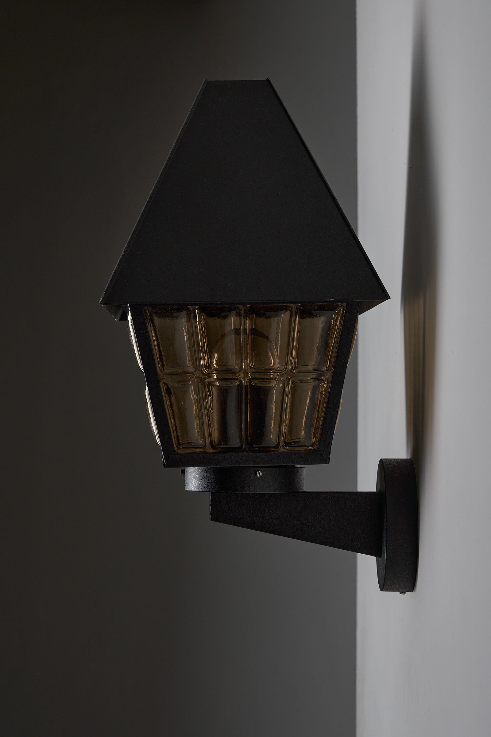Bega Boom Outdoor Wall Lantern showcasing textured amber glass, perfect for exterior lighting.