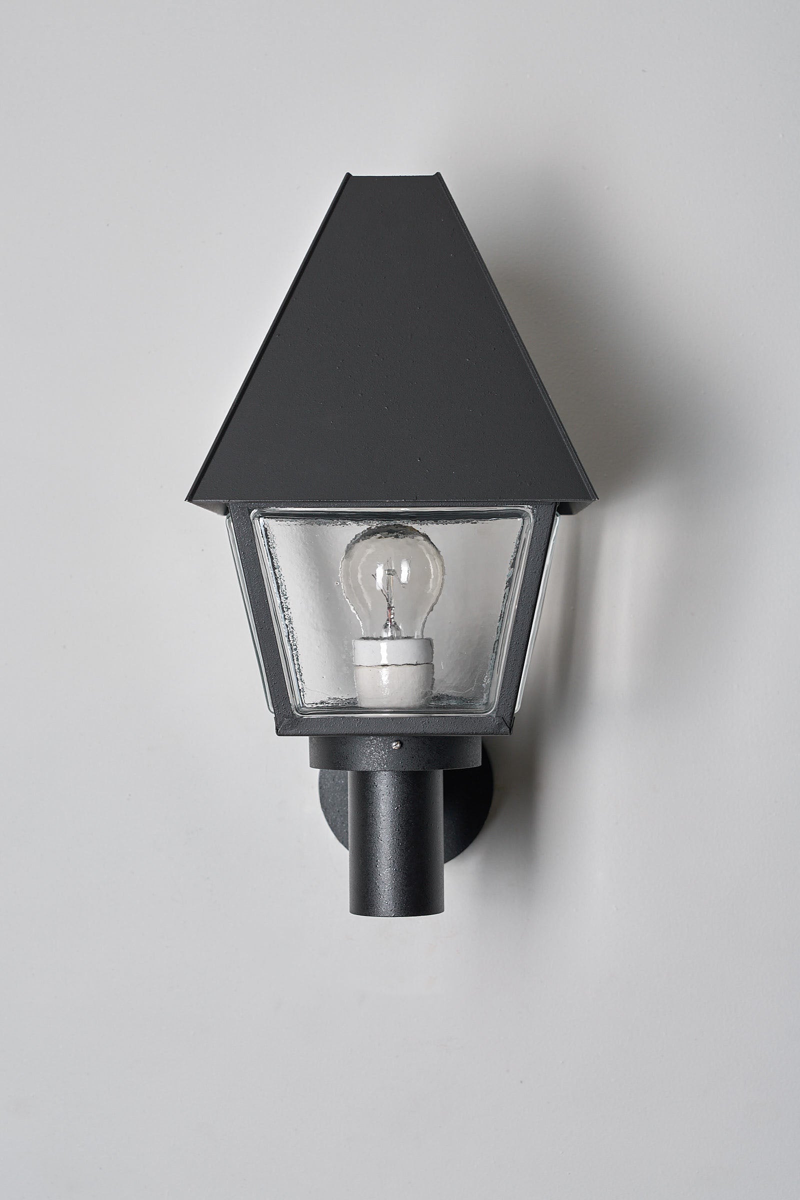 Bega Boom Outdoor Wall Light in dark textured metal with conical hood and clear textured glass for exterior lighting.