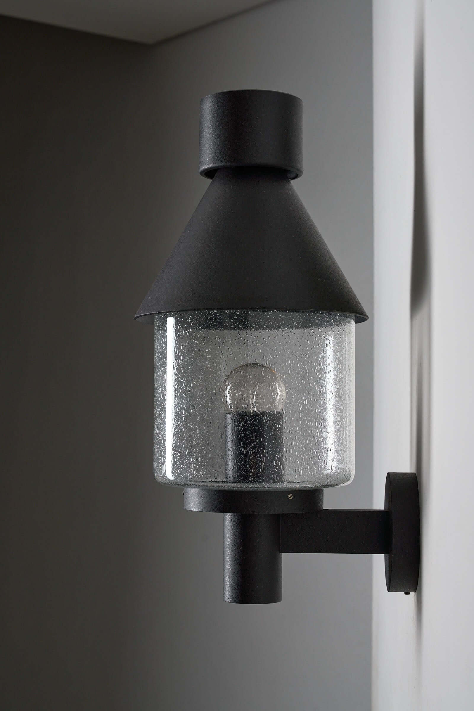 Bega Boom Outdoor Wall Light featuring a vintage exterior design with clear glass diffuser and conical shade.