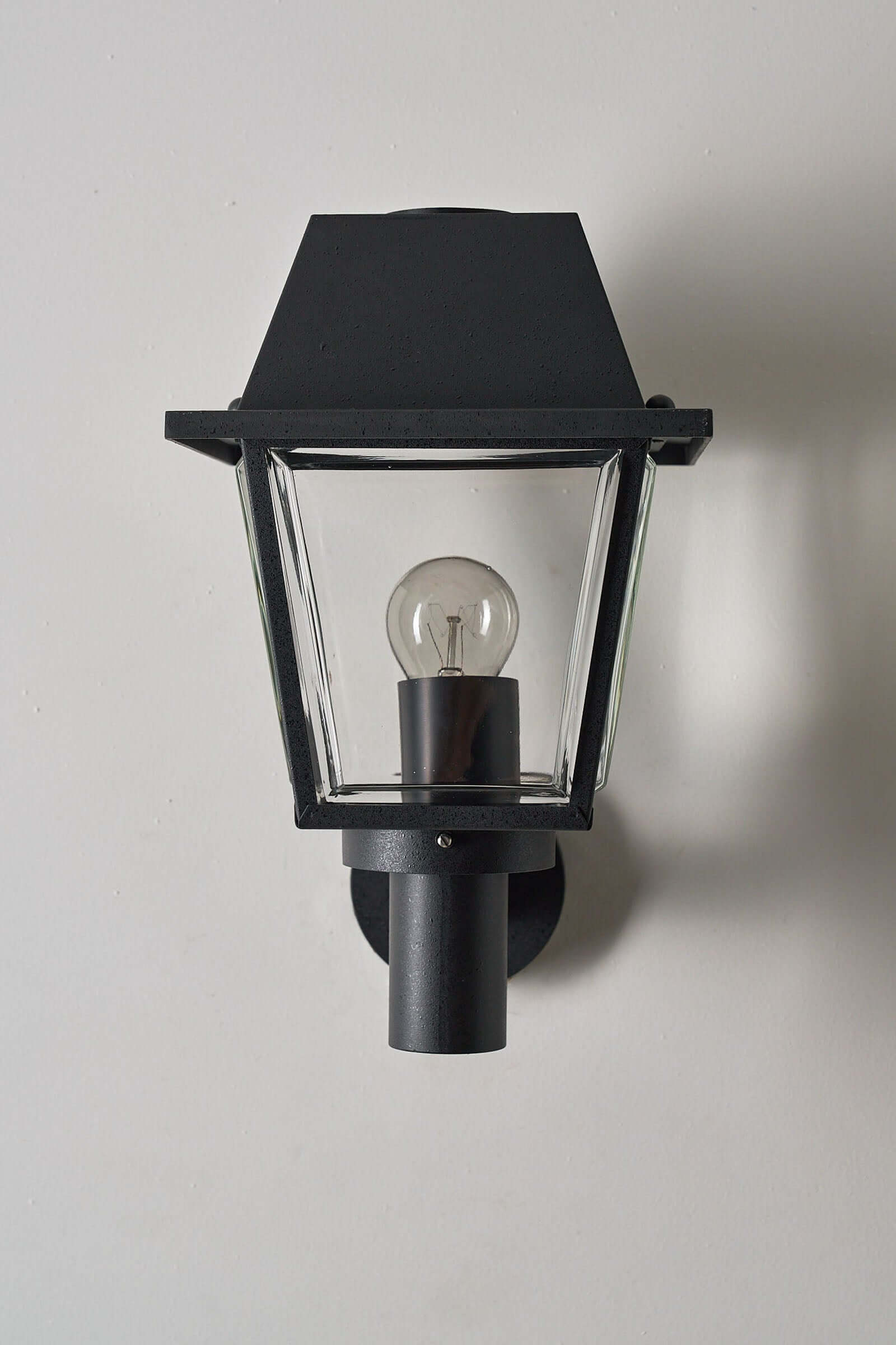 Outdoor Wall Lantern by Bega Boom, a modern traditional outdoor lamp with a conical hood and clear glass panels.