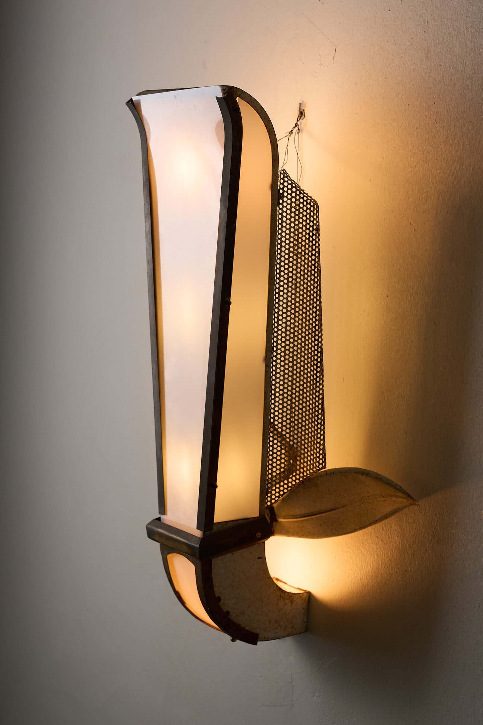 Grand Parisian Art Deco Wall Sconce featuring a tall diffuser and perforated metal design, illuminating a stylish interior.