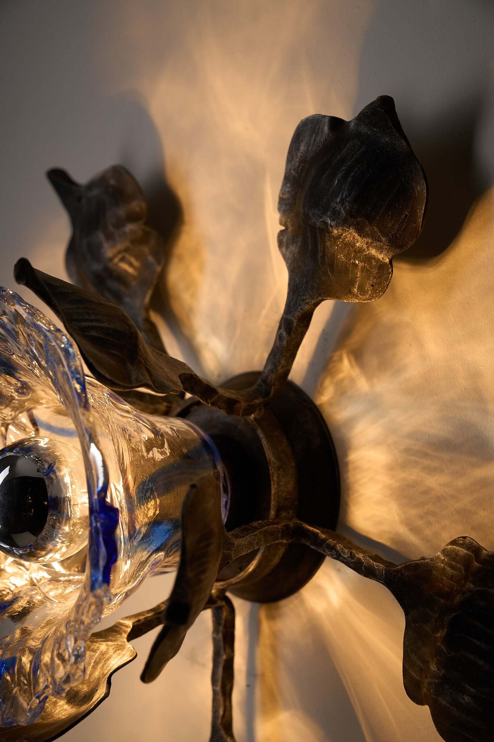 Brutalist Wall Sconce Cast Iron and Murano Glass by Ahlstrom & Ehrlich showcasing organic leaf design and blue diffuser.