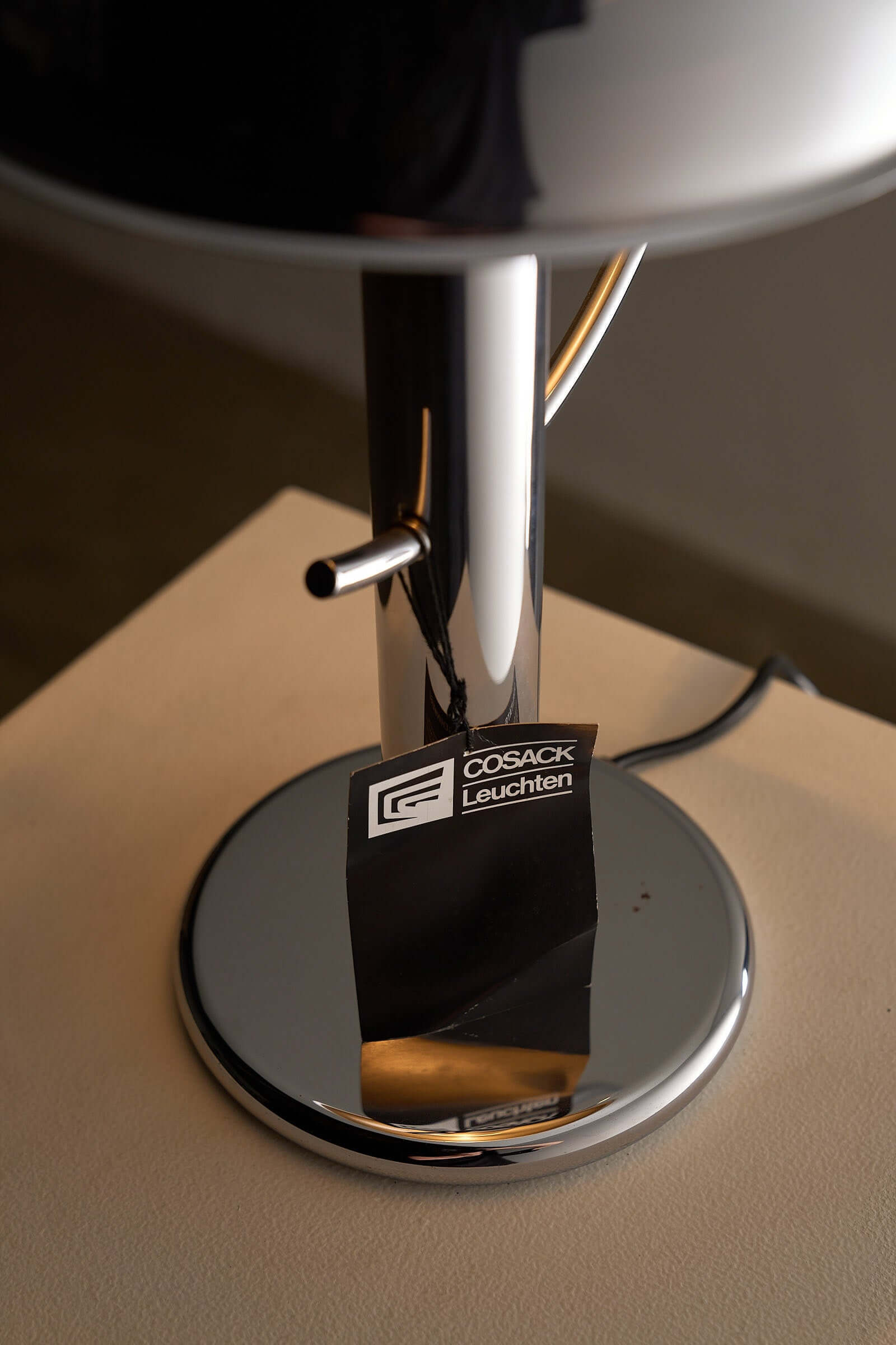 Cosack Chrome Semi-Sphere Desk Lamp base with logo showcasing its industrial design and chrome finish.