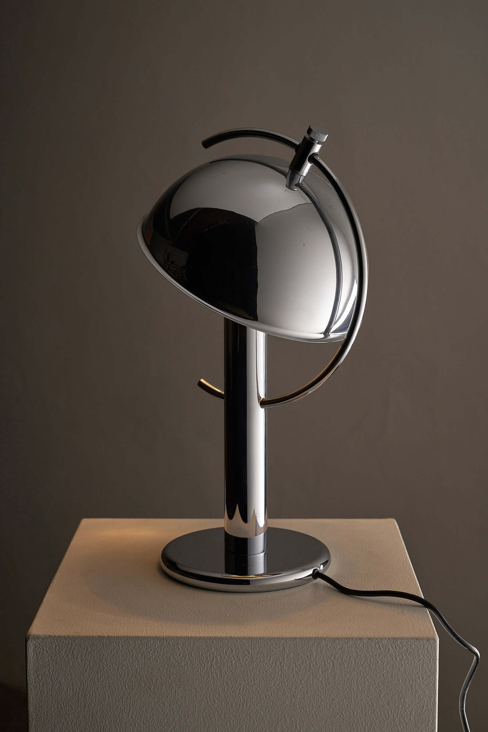 Cosack Chrome Semi-Sphere Desk Lamp on a pedestal showcasing its sleek, adjustable design perfect for outdoor lighting.