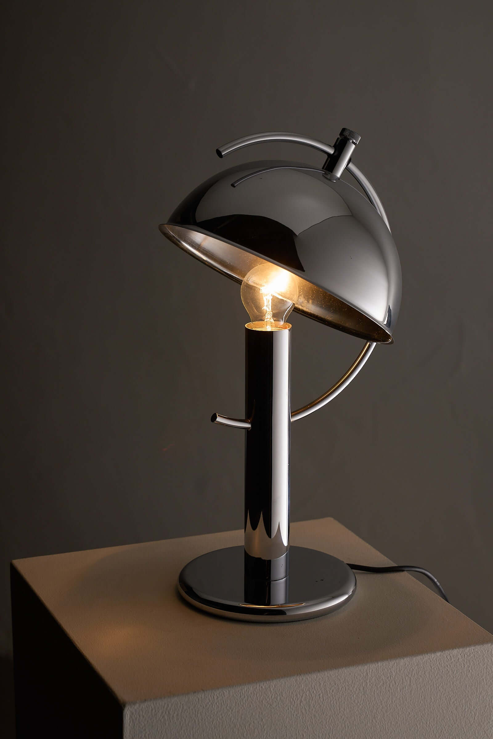 Cosack Chrome Semi-Sphere Desk Lamp showcasing its adjustable chrome design and focused task light.