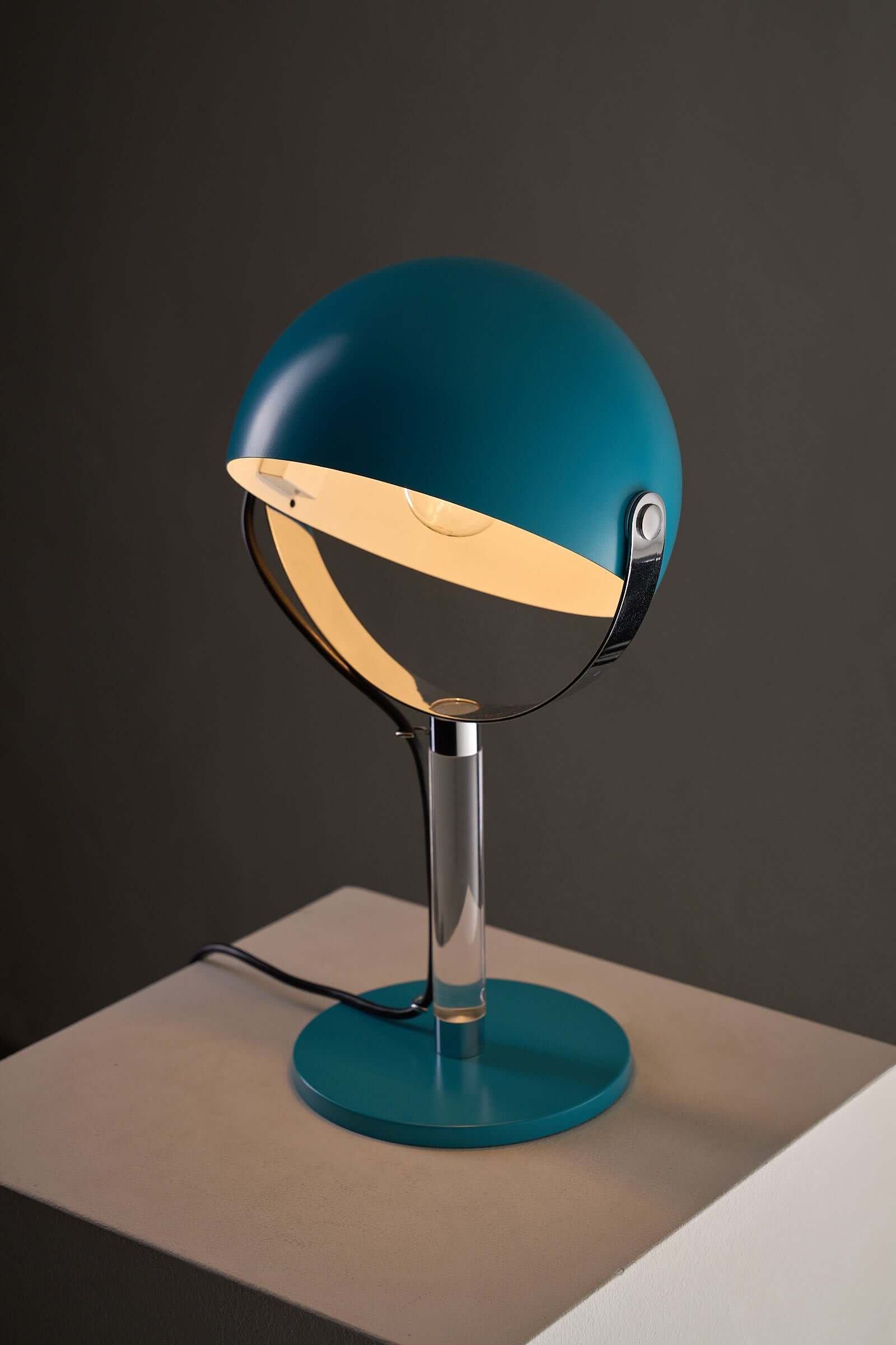 Turquoise Desk Lamp with Acrylic Stem on a white pedestal, showcasing its spherical shade and chrome gimbal arm.