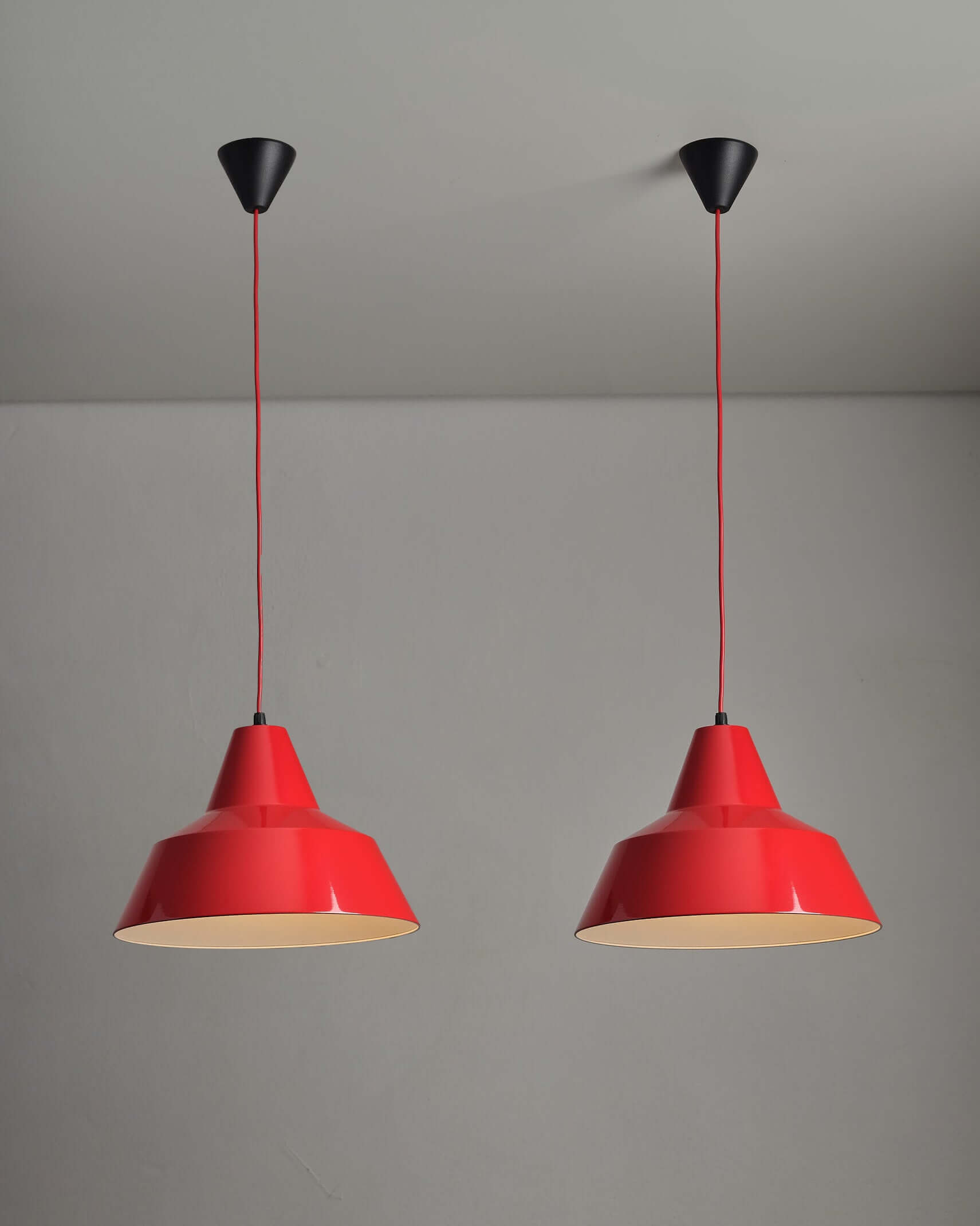 Red Industrial Warehouse Pendant Light by Lyfa hanging in a modern interior, showcasing its glossy red lacquer finish.