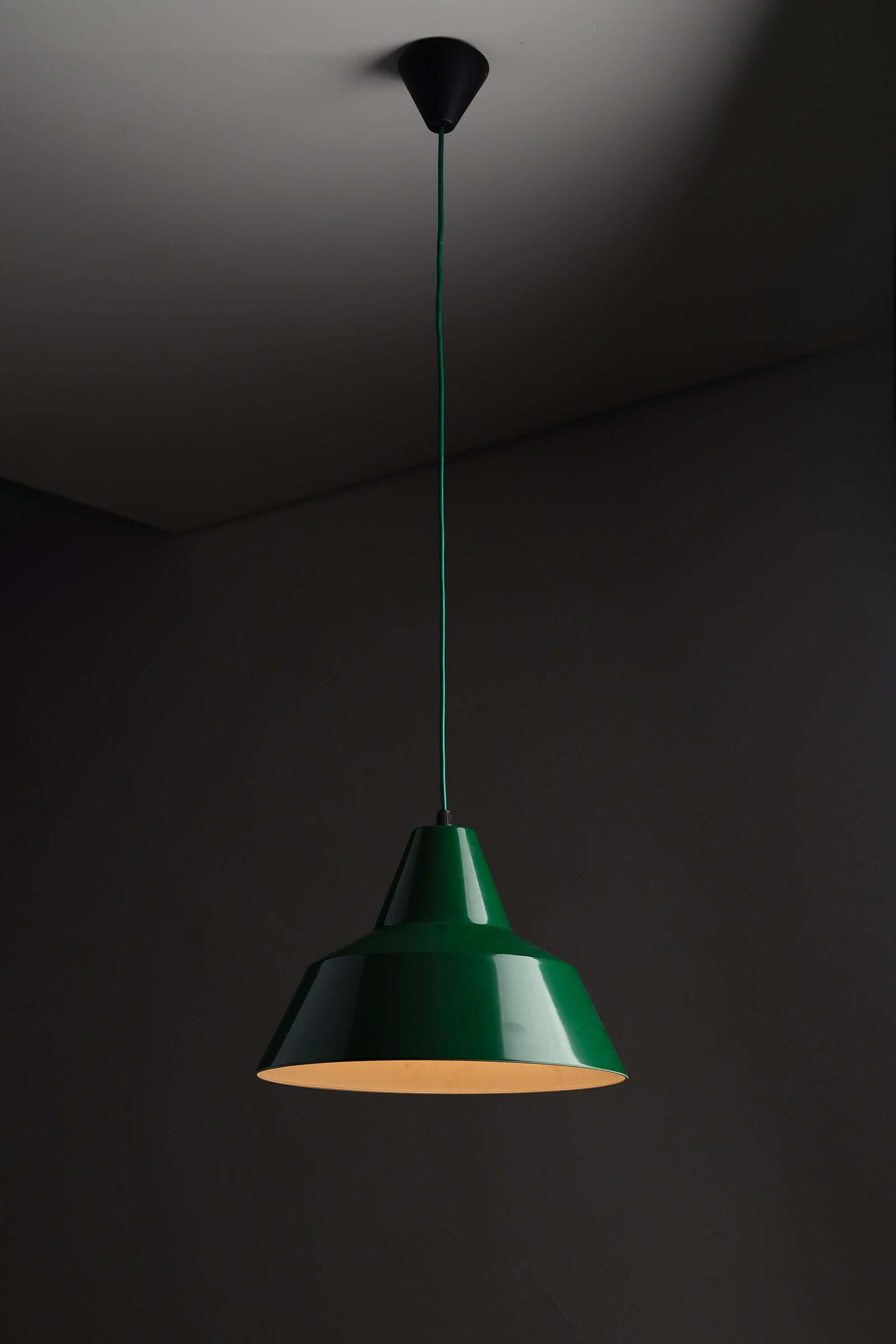 Green Danish Industrial Warehouse Pendant Light by Lyfa hanging in a dimly lit setting, showcasing its deep green lacquer finish.