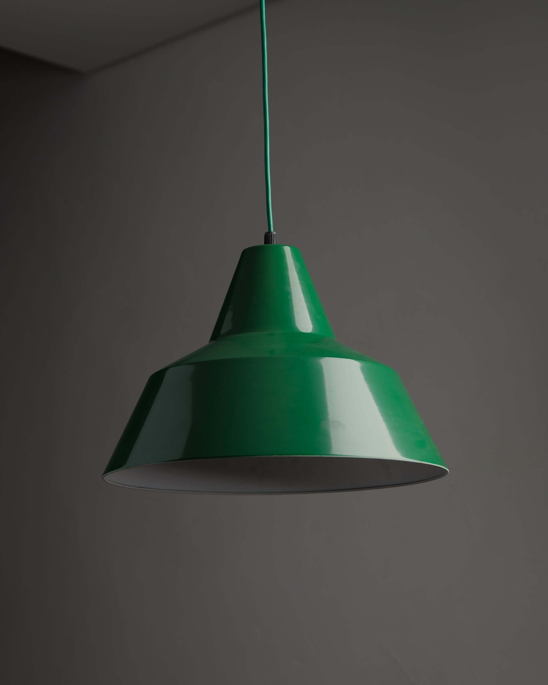 Green Danish Industrial Warehouse Pendant Light by Lyfa showcased in a minimalist setting, emphasizing its deep green lacquer finish.