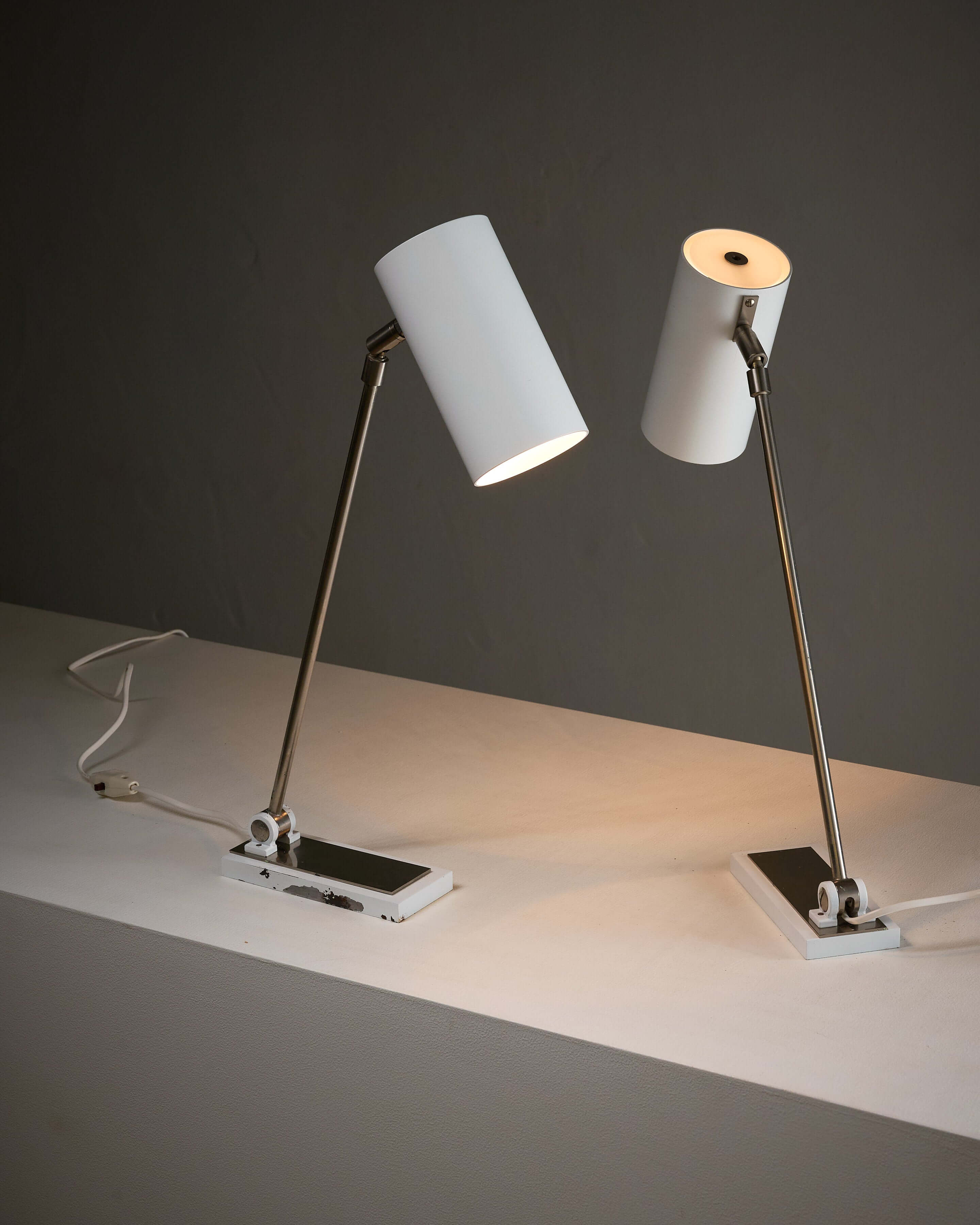 Minimalist White Cylinder Desk Lamp by Artiforte on a modern table showcasing adjustable lighting features.