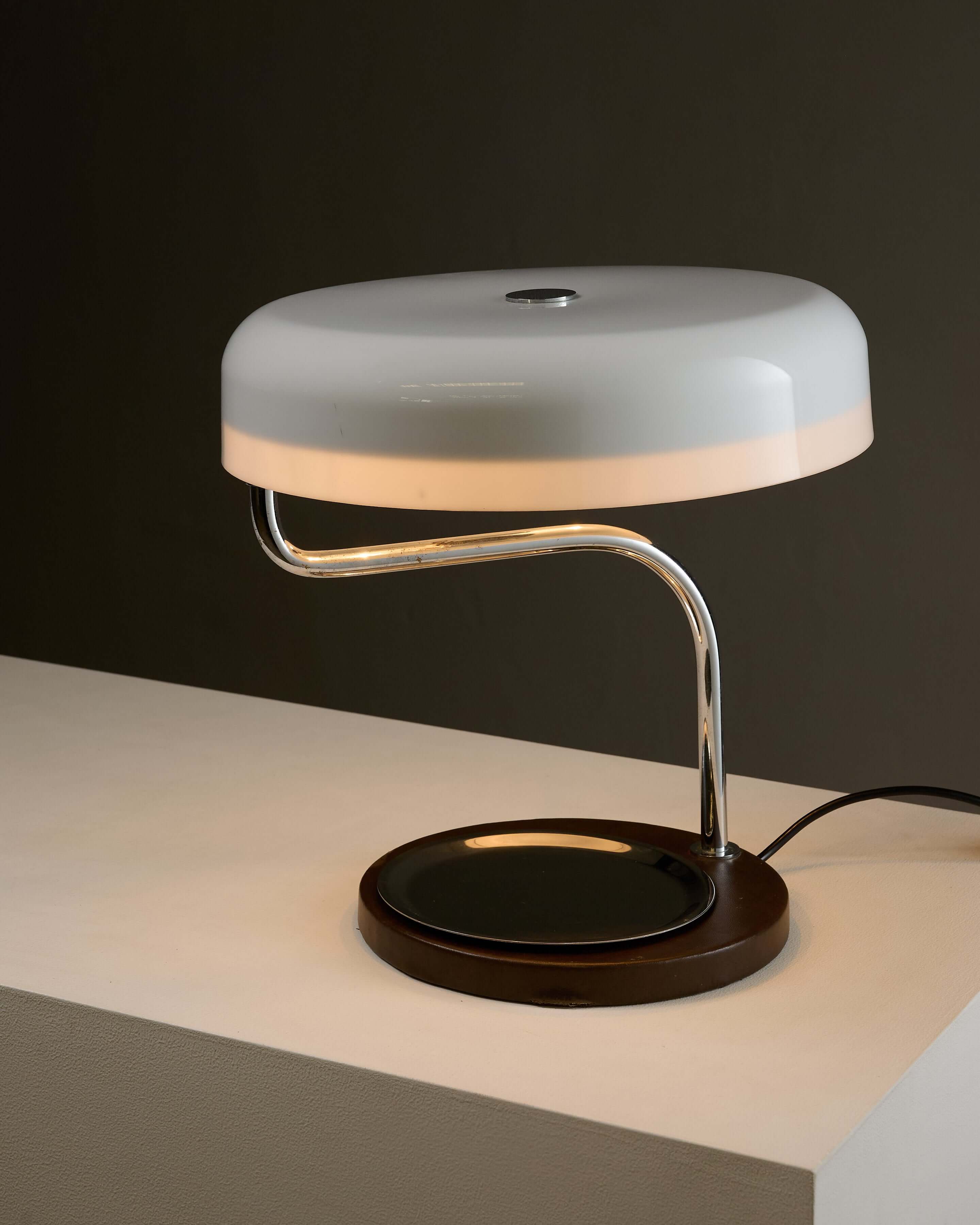 Metalarte Model 4817 Desk Lamp by Gaetano Scolari on a table showcasing a chrome arm and white methacrylate shade.