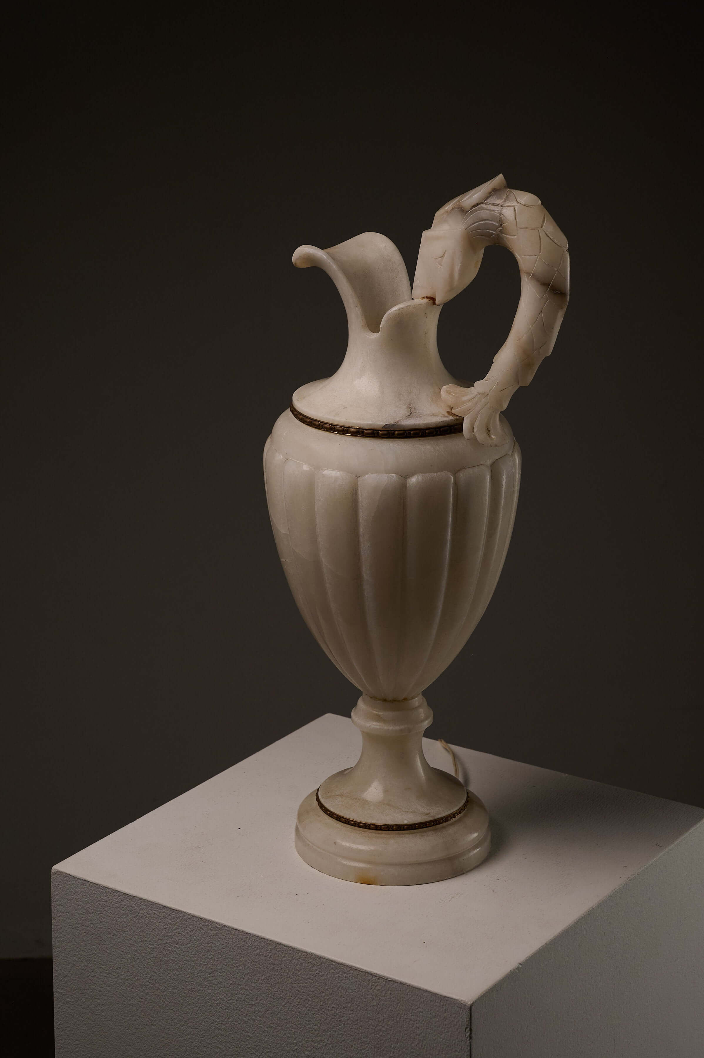 Carved Alabaster Urn Lamp with Stylized Fish Handle on a pedestal, showcasing neoclassical design.