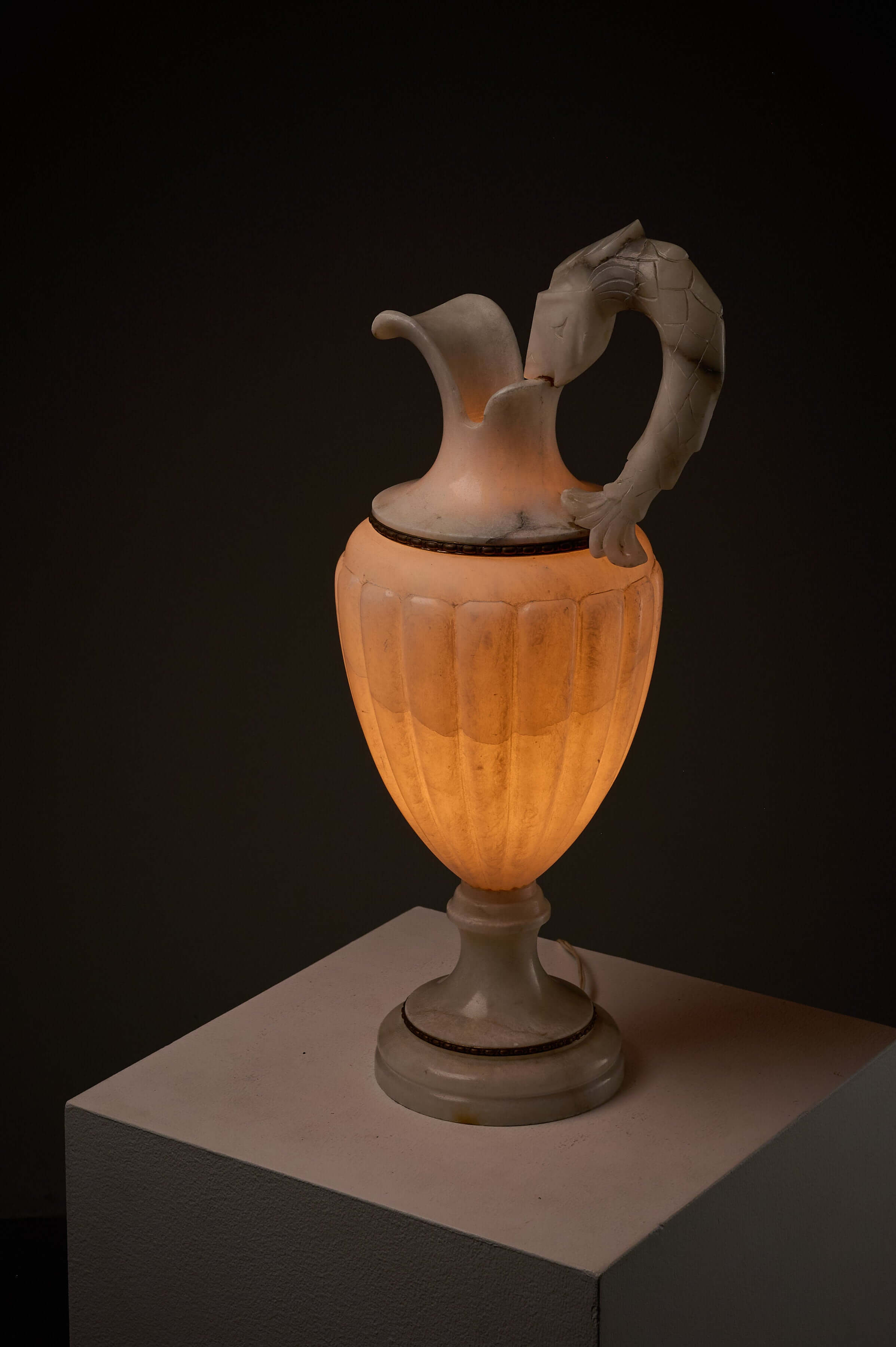 Carved Alabaster Urn Lamp with Stylized Fish Handle illuminated on display.