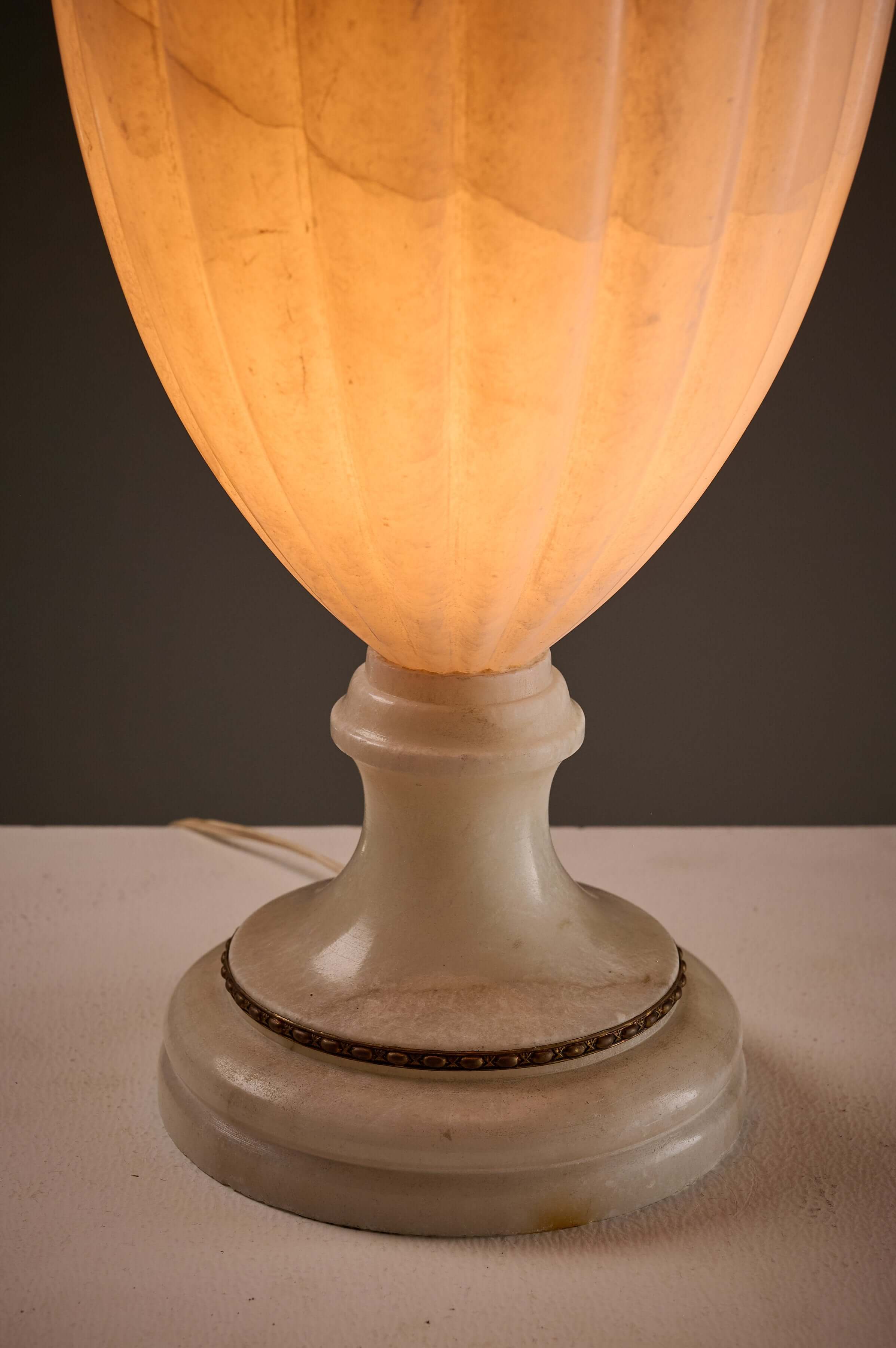 Carved Alabaster Urn Lamp with Stylized Fish Handle featuring an elegant alabaster base and soft warm glow.