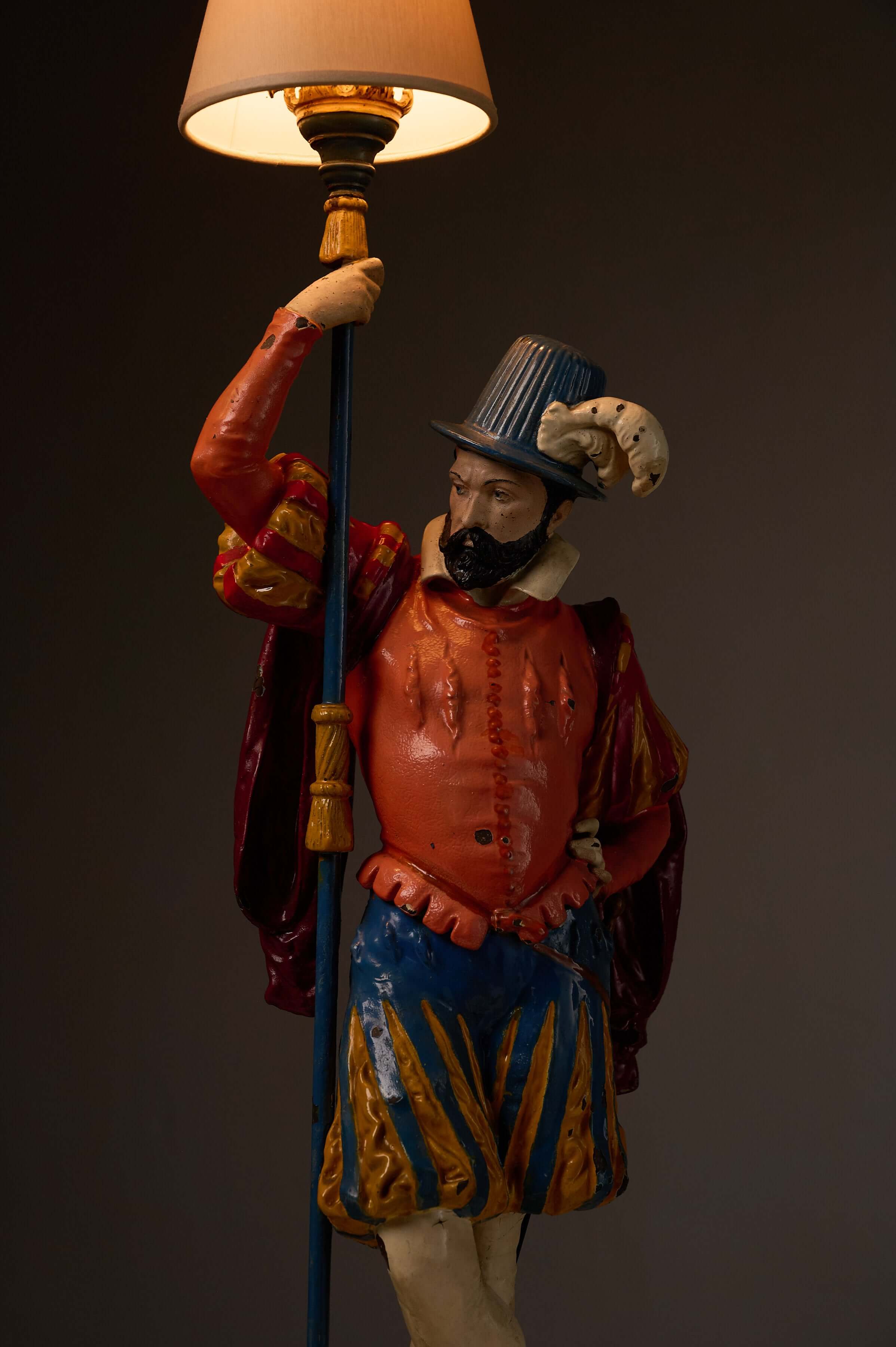 Pair of Painted Cast Iron Guard Figures Table Lamps featuring a musketeer figure in vibrant attire holding a lamp shade.