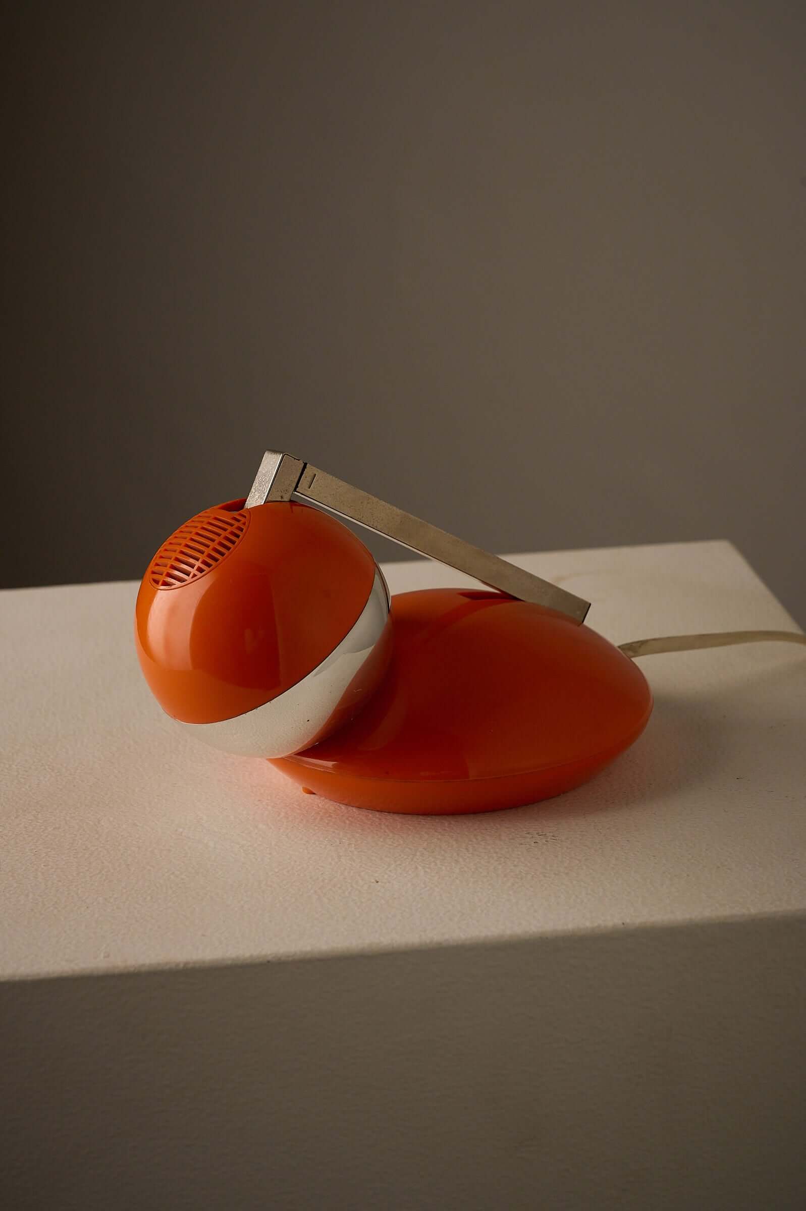 1970s Orange Pop Art Desk Lamp on a white pedestal with a chrome telescoping arm and orange plastic base.