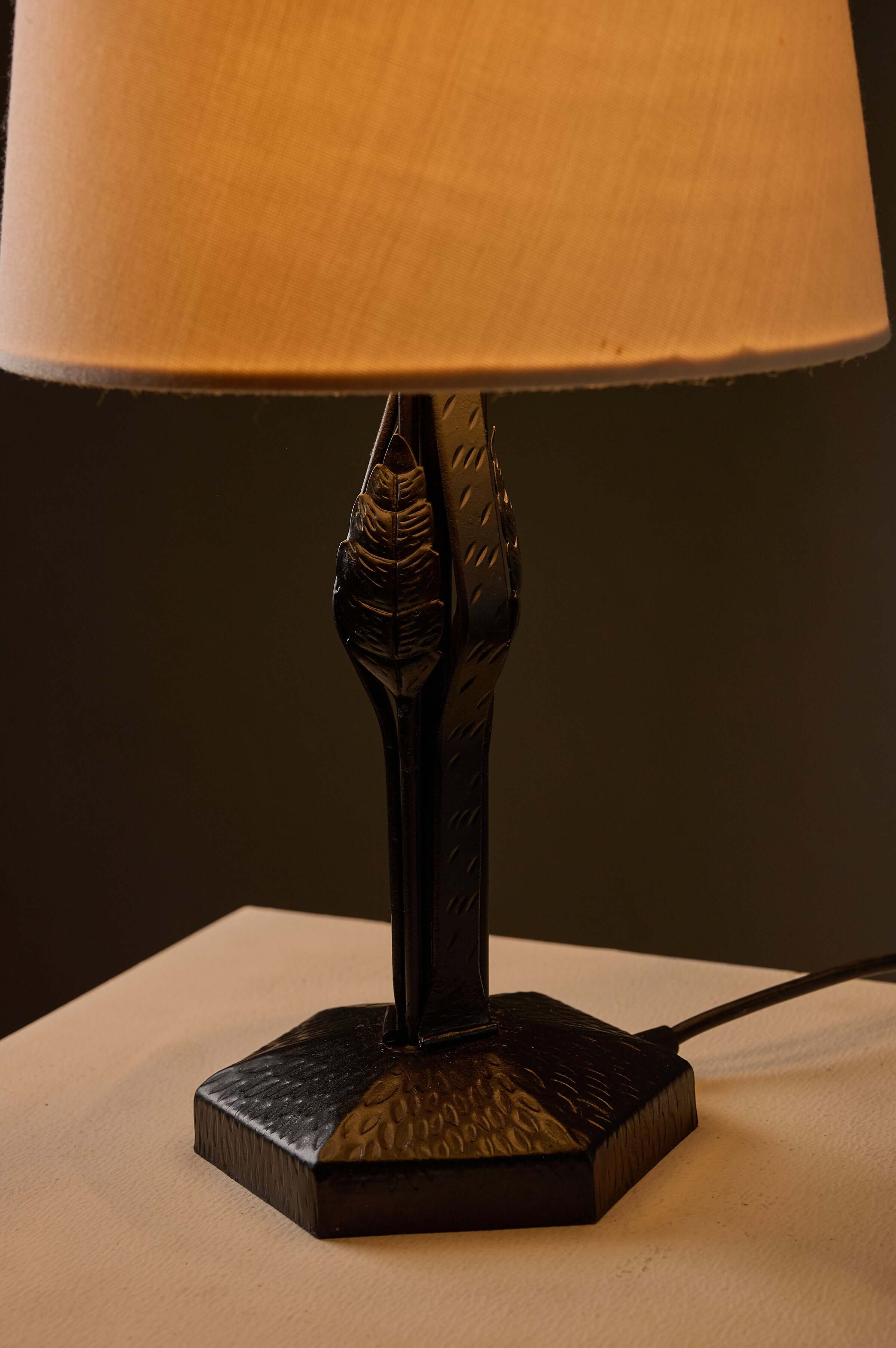 Black Hammered Metal Table Lamp with Stylized Leaf Motif on hexagonal base and fabric shade.