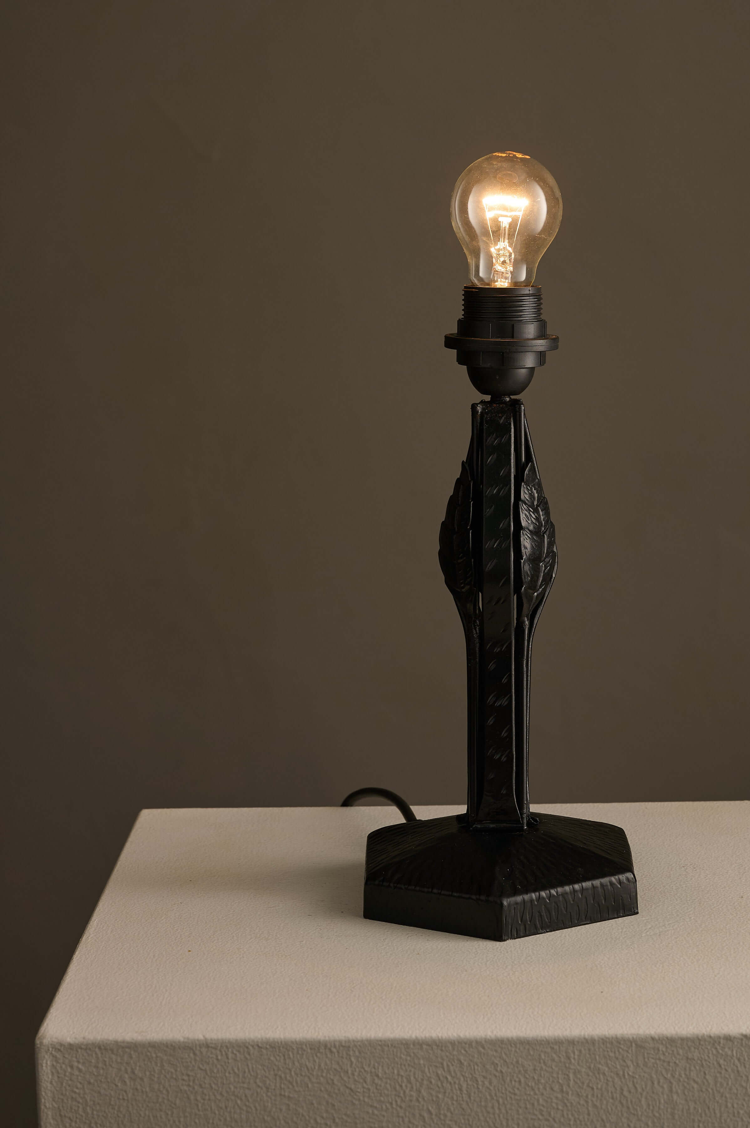 Black Hammered Metal Table Lamp with Stylized Leaf Motif on a hexagonal base and industrial design.