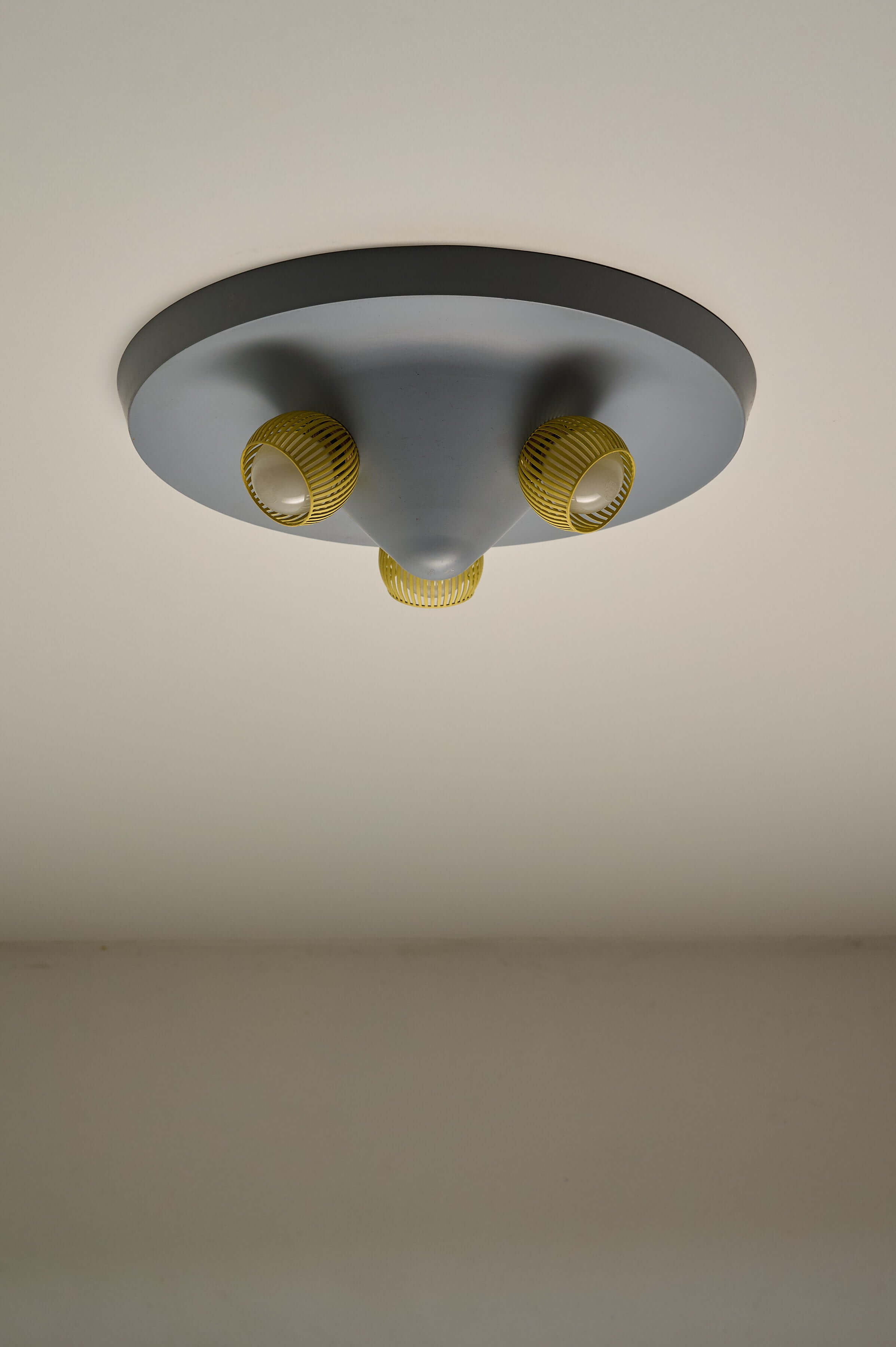 Mid-Century Grey Ceiling Flush Mount with Yellow Perforated Shades featuring three yellow shade cups.