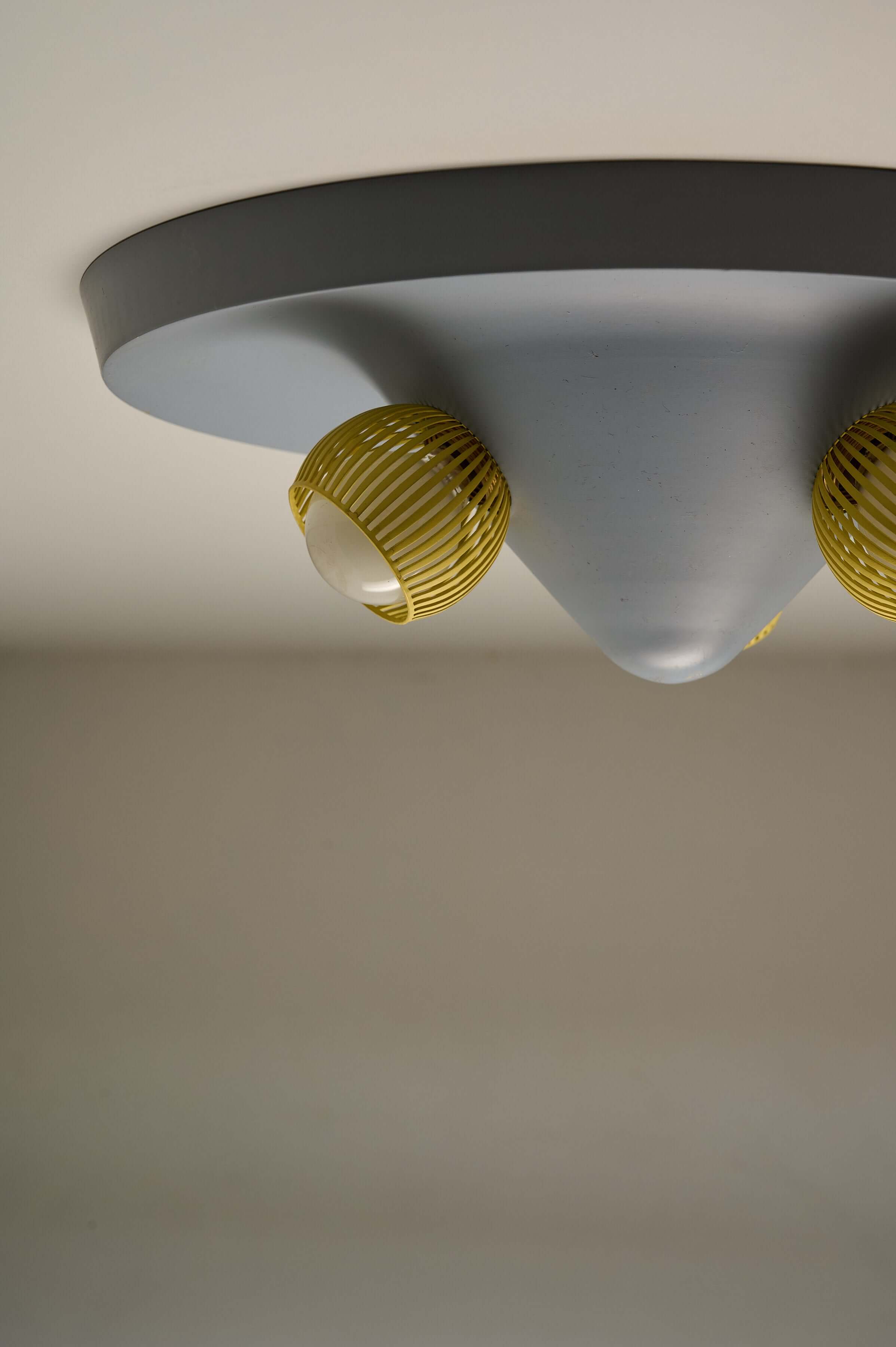 Mid-Century Grey Ceiling Flush Mount with Yellow Perforated Shades featuring a dynamic cone shape and striped yellow shades.