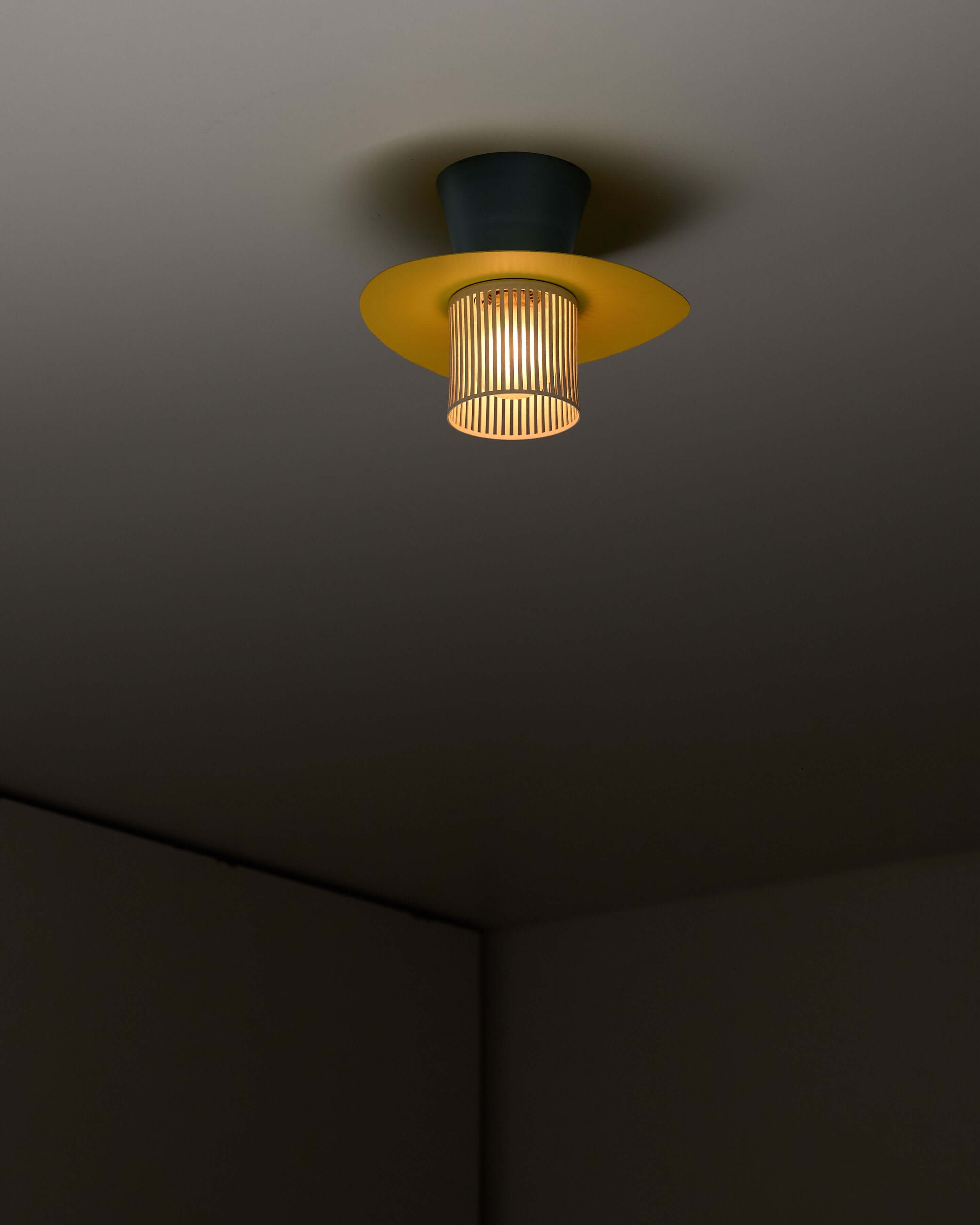 Mid-Century Plectrum Flush Mount in Yellow, Blue, and White illuminating a modern ceiling.